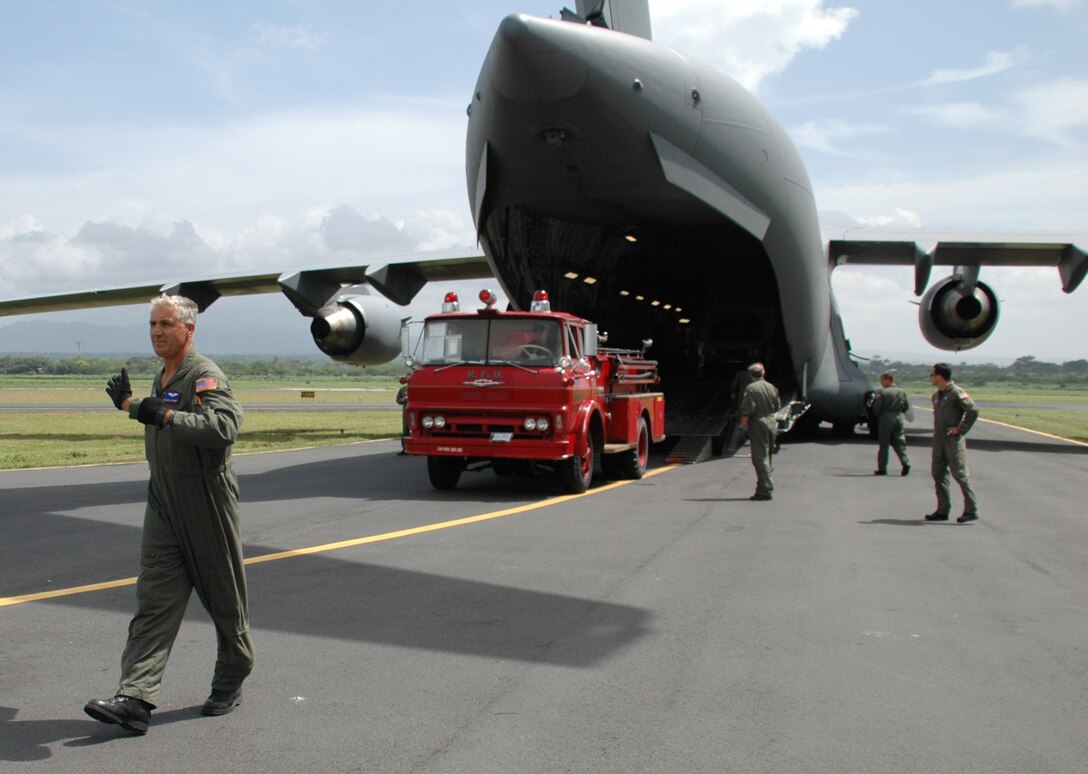 Tech. Sgt. George Thalman, a reserve loadmaster with the 701st Airlift Squadron, Charleston AFB, S.C., marshals a fire truck off a C-17 Globemaster III.  The donated fire truck was delivered to Nicaragua as part of the Denton program. (Photo by Capt. Wayne Capps, USAFR)