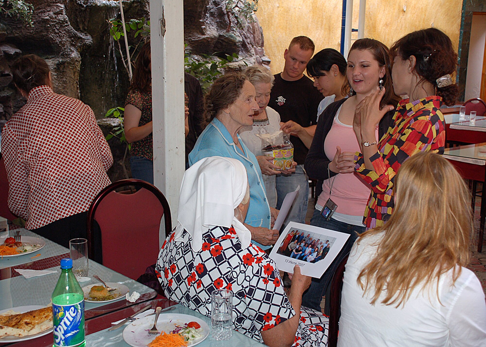 Airman 1st Class Ashley Babin listens as interpreter Janyl Sabirova (right) translates what one of the babushkas, or "grandmothers," is saying during a lunch visit to a restaurant July 27 in Bishkek, Kyrgystan.  Periodically, Airmen from the Manas Air Base Outreach Society host babushkas for lunch and also provide them with toiletries, clothing items and food.  Airman Babin is with the 376th Expeditionary Services Squadron.  (U.S. Air Force photo/Staff Sgt. Les Waters)
