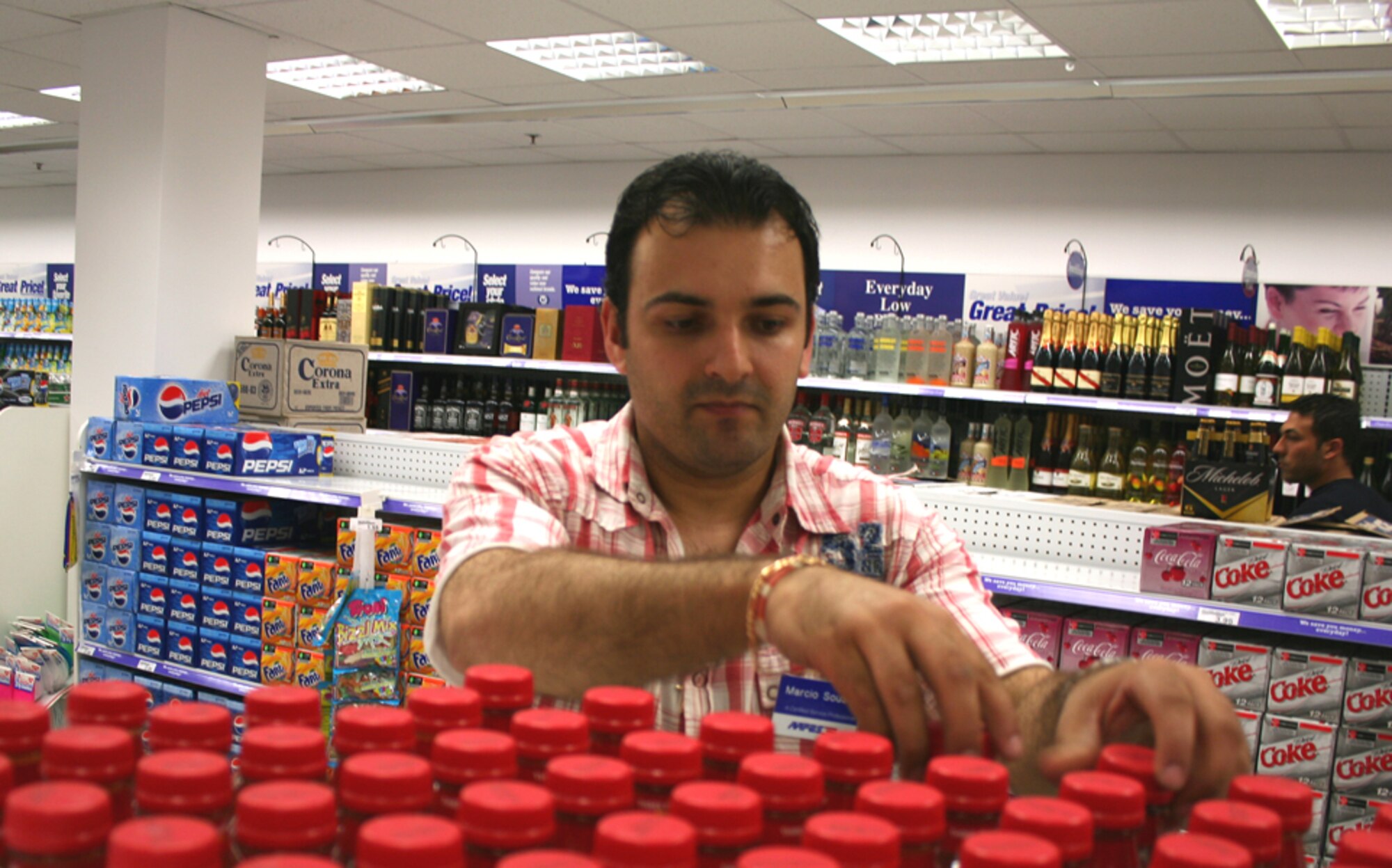 LAJES FIELD, Azores, Portugal -- Marcio Sousa, sales store checker, stocks shelves in the new shoppette here July 30. The new military clothing sales store, beauty shop, and barber shop are also co-located within the facility. The shoppette is open seven days a week. (U.S. Air Force photo by Staff Sgt. Marcus McDonald)