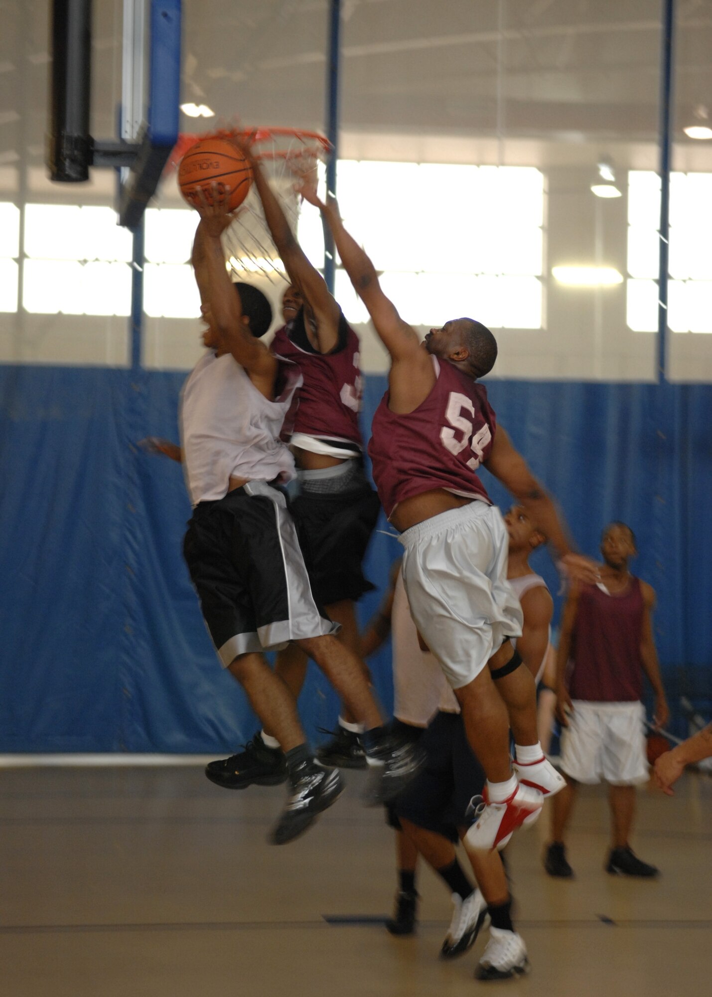 Airman 1st Class Christopher Napier struggles to get the ball away from his opponets during the Summer League Tournament championship game. The 49th Maintenance Squadron beat out the 49th Aircraft Maintenance Squadron 60-49. Airman Hudgies is on the 49 MXS team. (U.S. Air Force photo/Airman 1st Class Rachel Kocin)