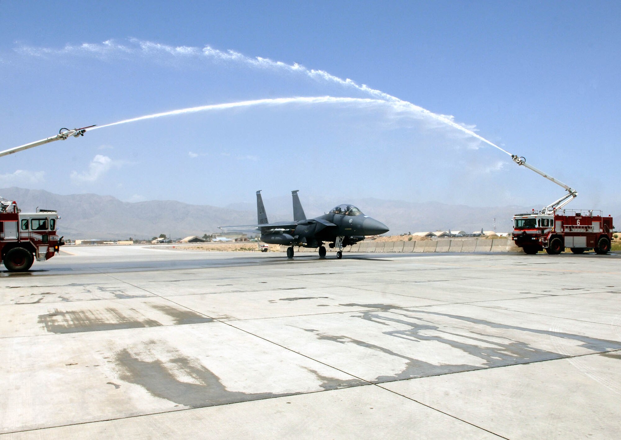 Upon landing, Lt. Col. Dave Iverson, 492nd Expeditionary Fighter Squadron director of operations, taxis through a arcing cascade of water shot from two fire department nozzles in a fighter squadron tradition of a post-flight “hose down” for flying achievements. Colonel Iverson recenly became the 15th pilot to achieve 3,000 flight hours upon landing after a mission July 25 at Bagram Airfield, Afghanistan. (U.S. Air Force photo)