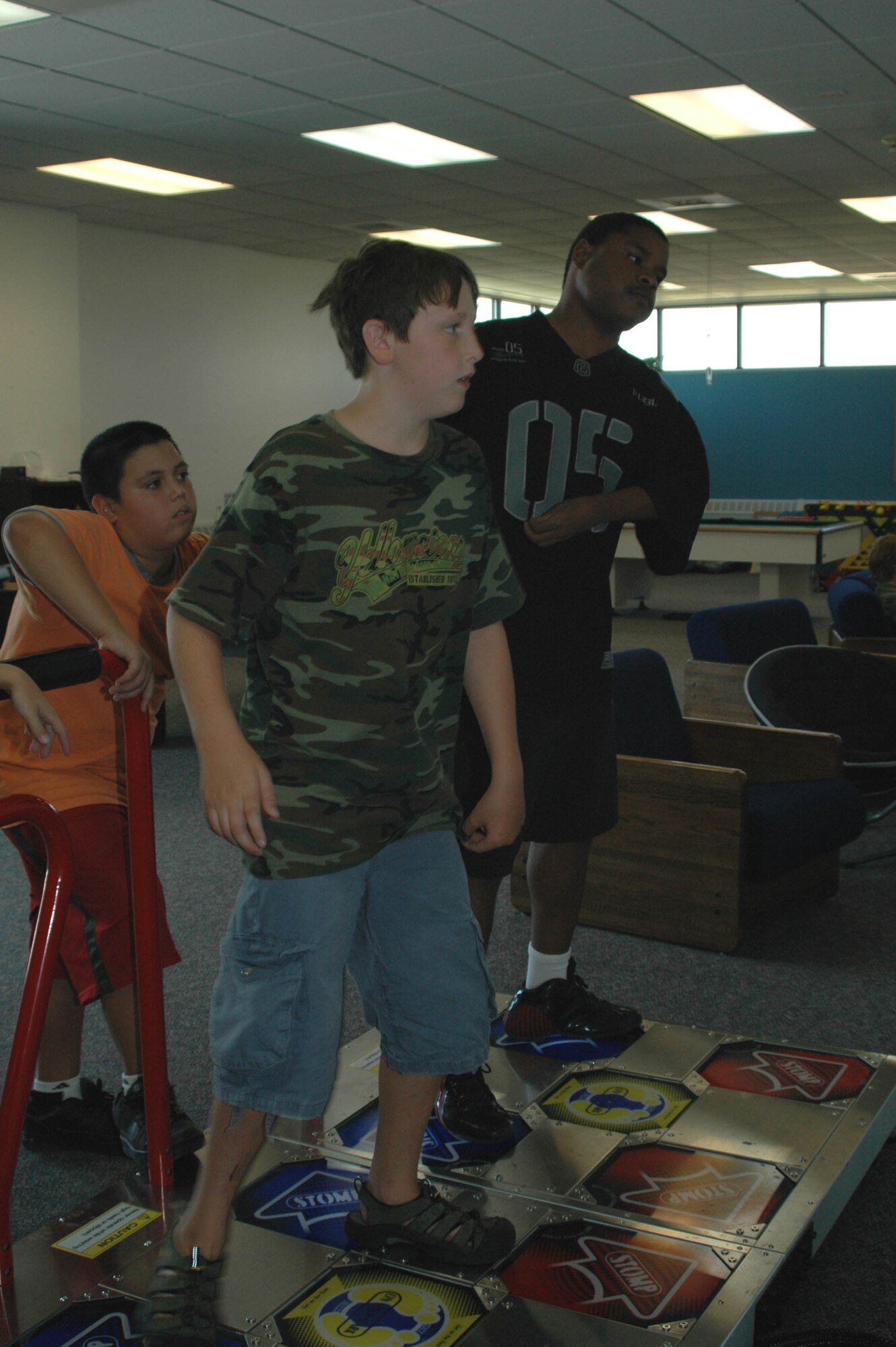 David, 11, and JB, 16, practice their moves and take advantage of the Youth Programs Center's new dance machine as Chris, 11, looks on. The YPC installed the dance machine three weeks ago. (U.S. Air Force photo / Airman 1st Class Emerald Ralston)