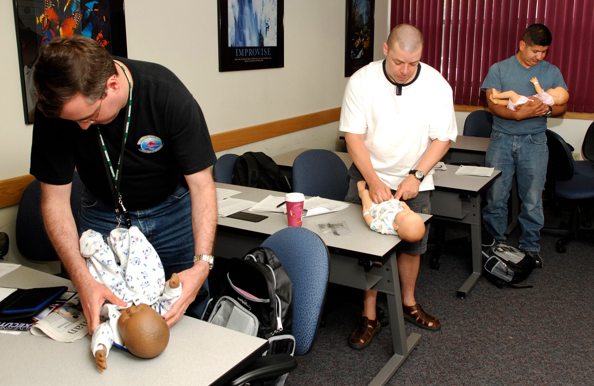 Dads and soon-to-be dads practice changing diapers during a Dads 101 class July 27. Expectant fathers or those who have a child younger than 6 months are invited to take part in these classes to learn to be great fathers. Col. Tom Schluckebier, 66th Air Base Wing commander, has authorized duty time for active-duty members and Department of Defense civilians to attend these classes. For more information on upcoming classes, call Family Advocacy Outreach at (781) 377-4617. (U.S. Air Force photo by Mark Wyatt)
