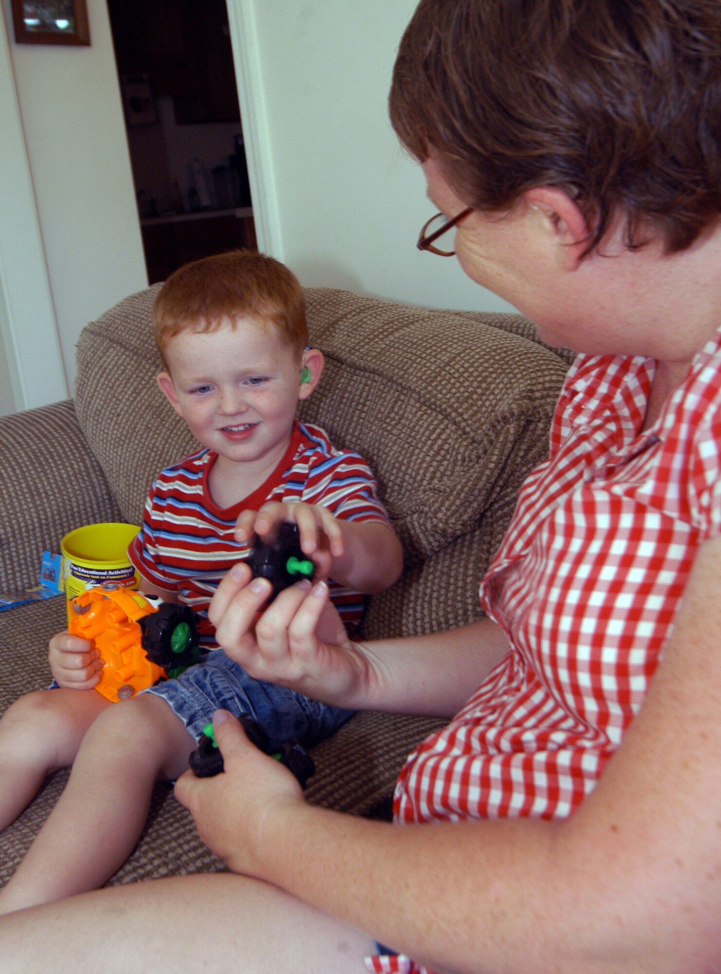 Elijah Hansen, 3,and his mother Angel play with some of his toys. He 
 has made great progress because of the Educational Developmental Intervention Service program. U. S. Air Force photo by Sue Sapp 