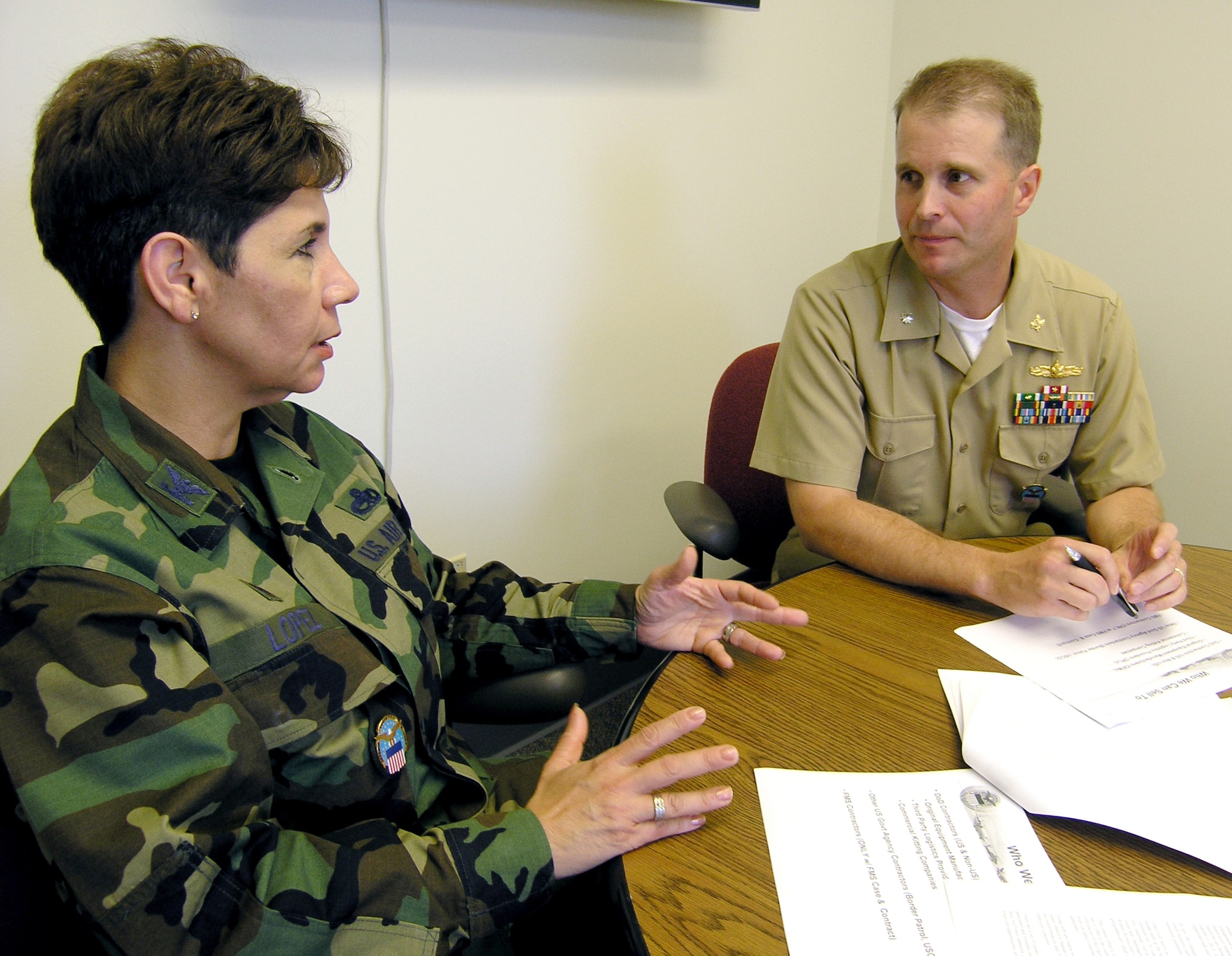 Air Force Col. Madeline Lopez discusses Defense Logistics Agency business with Navy Cmdr. Steve Morgan, deputy director of business development July 19 at Defense Supply Center Richmond. Lopez was recently named commander of DLA Warner Robins Air Logistics Center. DLA WRALC, located at Robins Air Force Base, Ga., is a detachment of DSCR. 