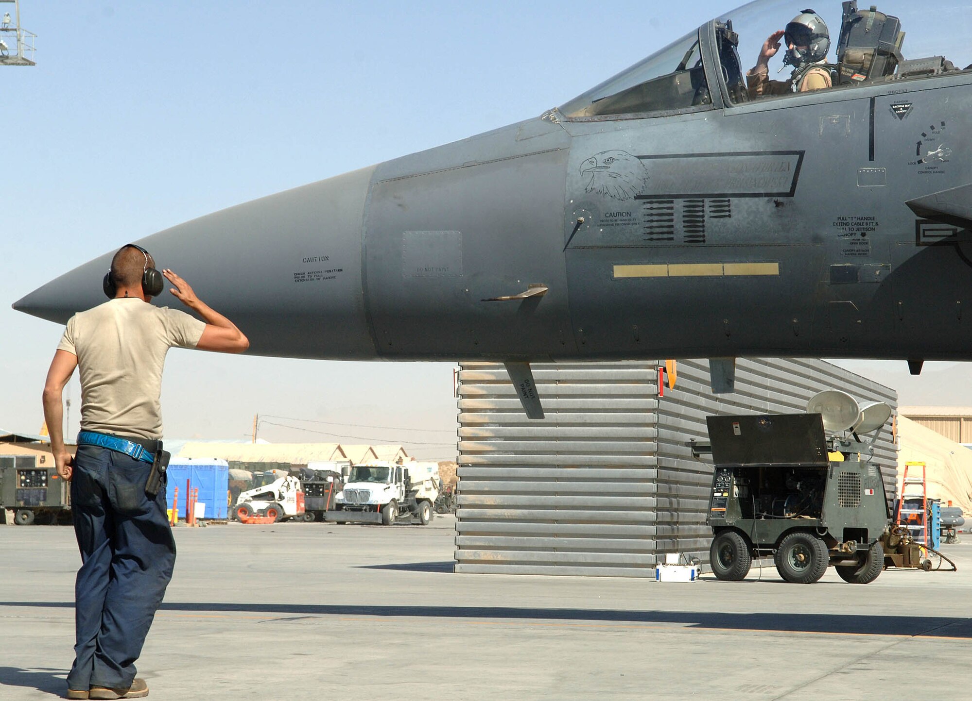 An F-15E Strike Eagle crew chief assigned to the 492nd Expeditionary Aircraft Maintenance Unit salutes the pilot prior to his flight August 2 from Bagram Airfield, Afghanistan. (U.S. Air Force photo by Staff Sgt. Craig Seals)