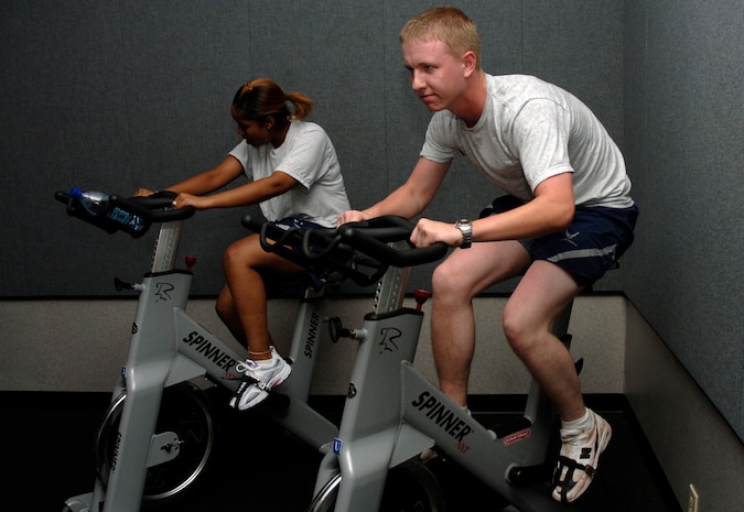 Christopher Freeman, 437 Logistics Readiness Squadron, and Laqeca Young, 437 MSS, pedal through a scheduled physical training spin session at the base Fitness and Sports Center. (U.S. Air Force Photo/Staff Sgt. April Quintanilla)