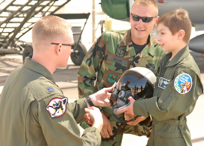 Capt. Chad Burdick, 309th Fighter Squadron instructor pilot and Senior Airman Jeffrey Braun, 756th Aircraft Maintenance Squadron crew chief, chat with Max Marangella, 6, July 27 prior to Max sitting in the cockpit of an F-16 Fighting Falcon. It was part of a full day of activities planed for Max as the pilot-for-a-day.  (Photo by Airman 1st Class Gustavo Gonzalez)
