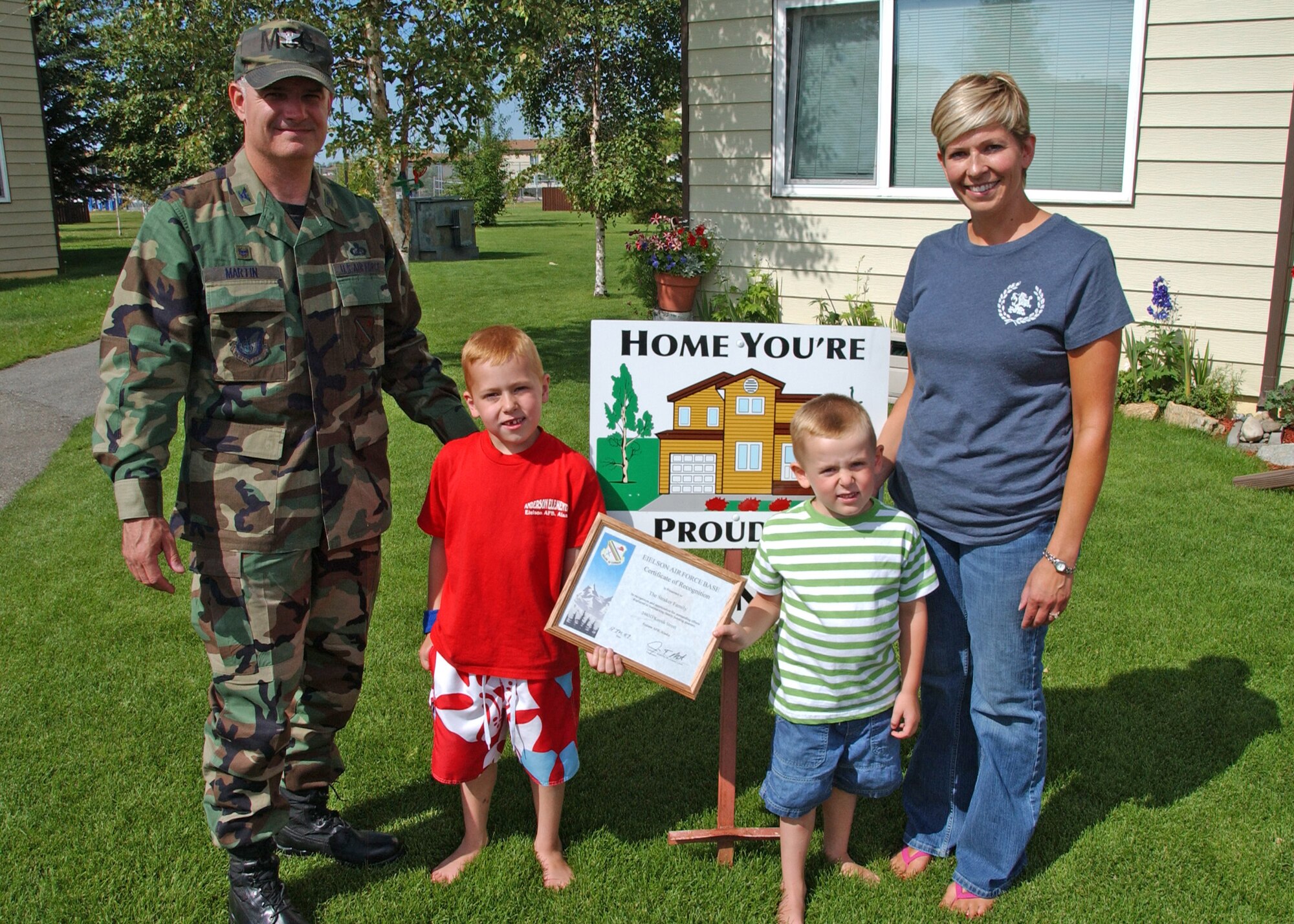 EIELSON AIR FORCE BASE, Alaska--Home You're Proud Of winners, Tech. Sgt. Eric Straker (not pictured) of the 354th Logistics Readiness Squadron, wife, Janice and sons Gordon and Toby pose for a picture with Col. Martin, former 354th Mission Support Group commander. The Strakers won the HYPO award for Area 2 for the month of June; each winning household received $125 in giftcards from various units on base and businesses off base. (U.S. Air Force photo by Airman 1st Class Christopher Griffin)
