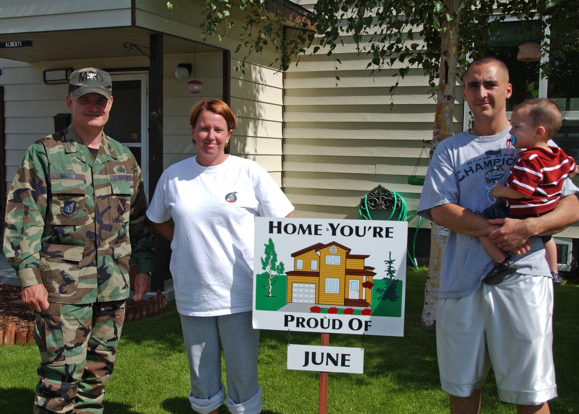 EIELSON AIR FORCE BASE, Alaska--Home You're Proud Of winners, Staff Sgt. Jason Alberti, 353rd Combat Training Squadron, wife, Emily and son, Jacob, pose for a picture with Col. Martin, former 354th Mission Support Group commander. The Albertis won the HYPO award for Area 3 for the month of June; each winning household received $125 in giftcards from various units on base and businesses off base. (U.S. Air Force photo by Airman 1st Class Christopher Griffin)        