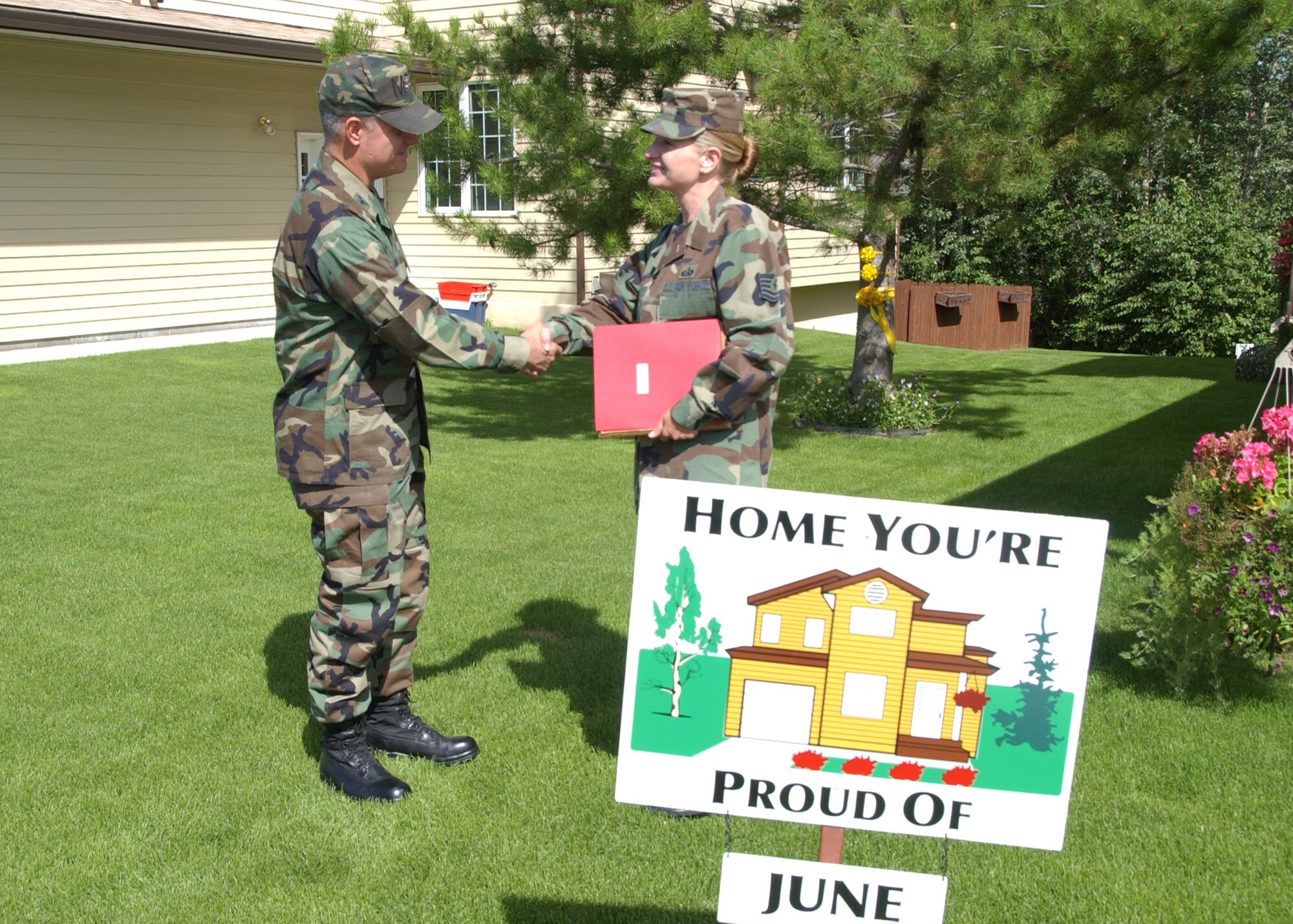 EIELSON AIR FORCE BASE, Alaska--Home You're Proud Of winner, Tech. Sgt. Elizabeth Molloy, 354th Civil Engineer Squadron, and husband, Chief Master Sgt. Eric Molloy, 354th Security Forces Squadron (not pictured), shakes the hand of Col. Martin, former 354th Mission Support Group commander. The Molloy's won the HYPO award for Area 1 for the month of June; each winning household received $125 in giftcards from various units on base and businesses off base. (U.S. Air Force photo by Airman 1st Class Christopher Griffin)                      