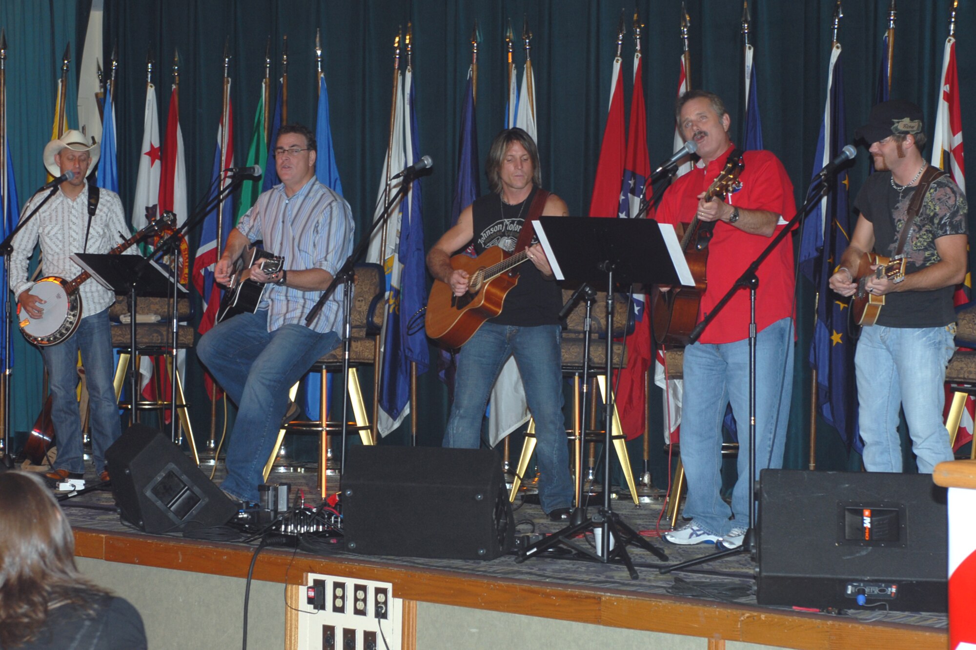 The rain was falling outside July 24 at Luke, but it was also falling inside at the Desert Star Club, as the band Carolina Rain treated nearly 140 base personnel, including Brig. Gen. Tom Jones, 56th Fighter Wing commander, to more than an hour of music. In addition, radio stars of KNIX, Tim and Willie, acted as emcees and performed with the group. From left: Carolina Rain banjo player, guitarist and vocalist Marvin Evatt, KNIX disc jockey, Tim, Carolina Rain lead singer and guitarist, Rhean Boyer, Willie and mandolin player and vocalist Jeremy Baxter. The band entertained with a mixture of songs, ballads, harmonies, and stories of the road and life. (Photo by Staff Sgt Darrell Dean)