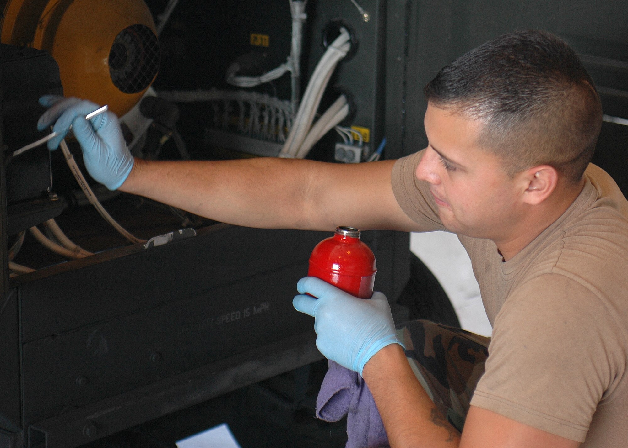 Senior Airman Michael Hernandez, 49th Maintenance Squadron, brushes lubricant over the hinges on a piece of Aerospace Ground Equipment. Airman Hernandez is part of the AGE flight. (U.S. Air Force photo/Airman 1st Class Heather Stanton)