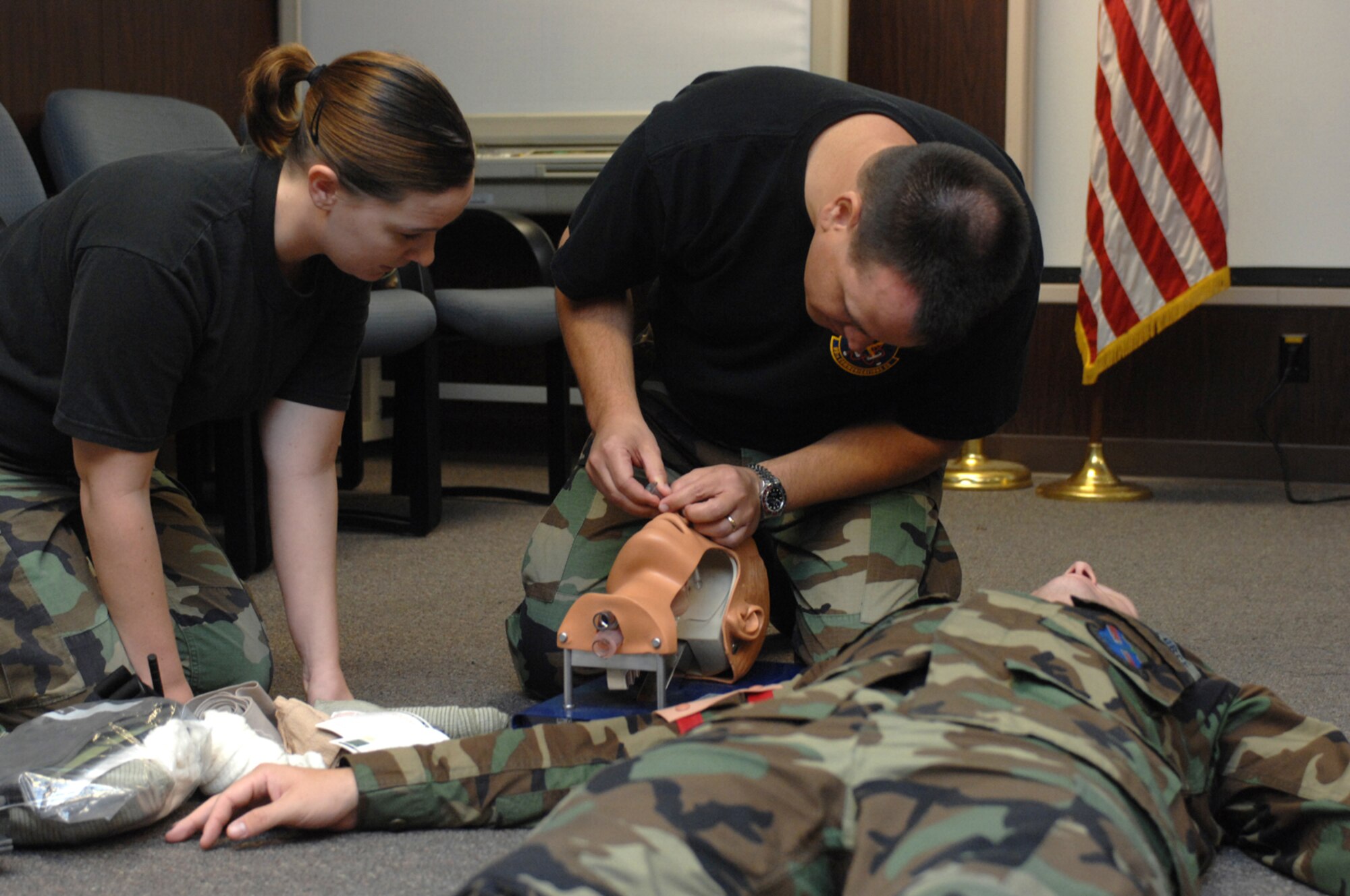 Senior Airman Heather Stidham, 99th Communications Squadron, videographer and Lt. Col. Matthew Haber , 99th Communications Squadron commander, are evaluated on the correct procedures to treating an unconscious victim during a Self Aid and Buddy Care Class July 26, 2007. Before deploying Airmen are required to be familiar with some of the situations they may find themselves in while deployed.  
(U.S. Air Force Photo by Airman 1st Class Nadine Y. Barclay)