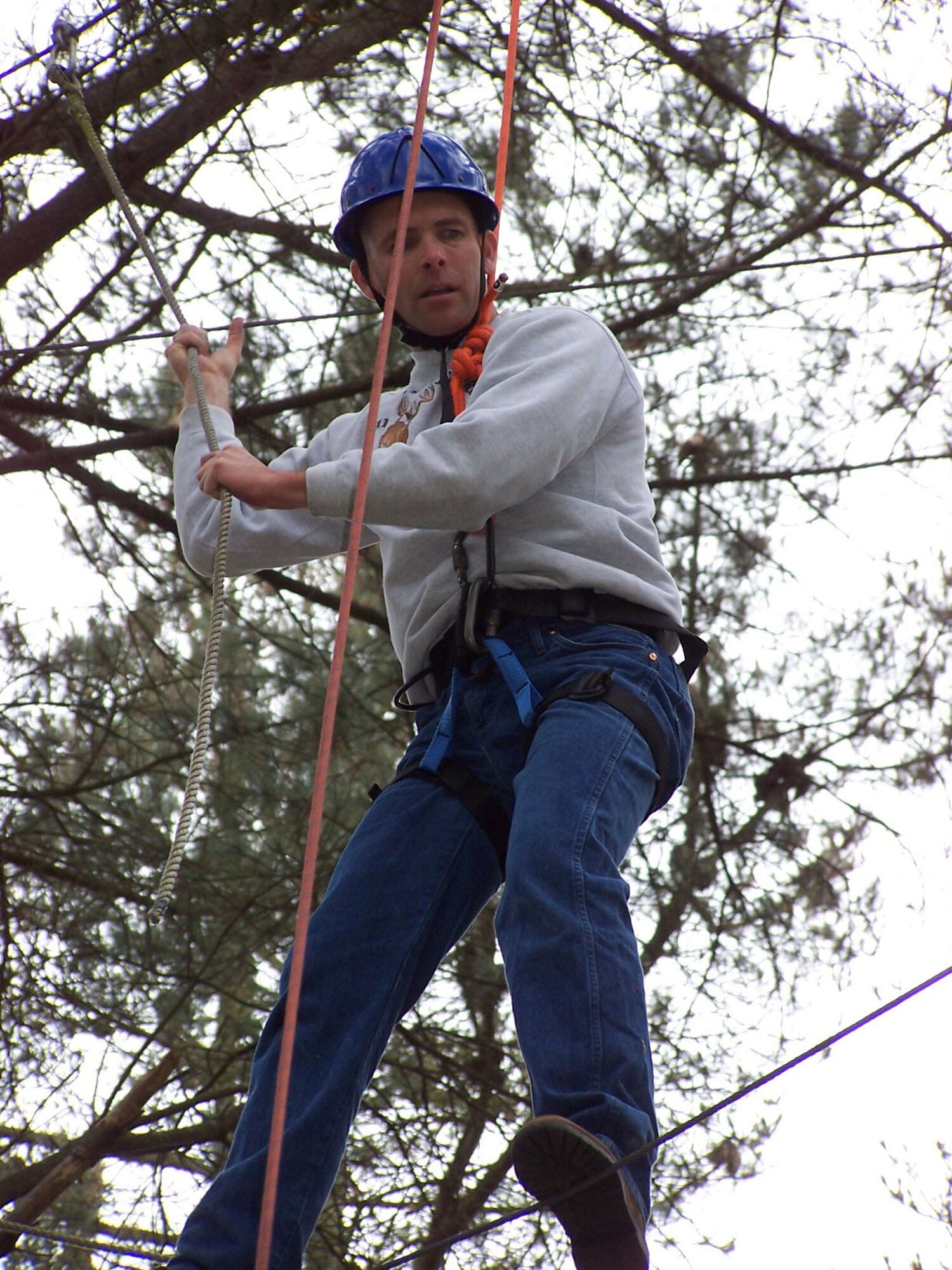 Master Sgt. Michael Ammons, 341st Medical Group first sergeant, walks on a tight rope high above the group and among the treetops during a ropes course teamwork exercise In May. The Air Force master sergeant attended the Coast Guard's Chief Petty Officer Academy in Petluma, Calif., in lieu of the Air Force's Senior NCO Academy required for his professional military education. (U.S. Air Force photo)