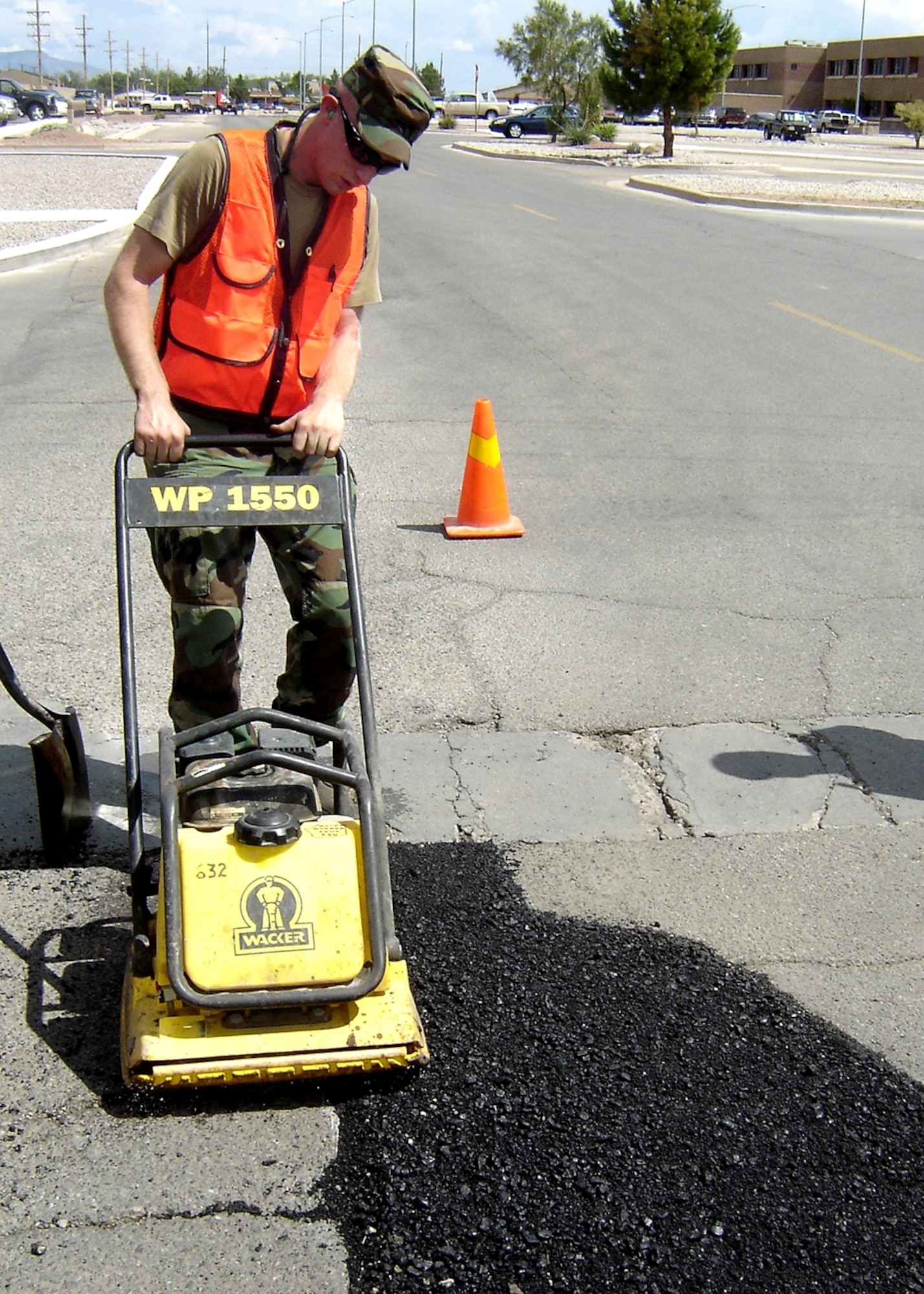 Staff Sgt. Jeremiah Shelton, 49th Civil Engineer Squadron, uses a vibrating “plate tamper” to compact the patch mix and make it fit flush with the road surface to fill a pot hole at the intersection of Tabosa and Arkansas July 31. This was the 13th pot hole filled for the 49 CES team that day and they were still going to get to more. (U.S. Air Force photo/1st Lt. Daniel Camacho)