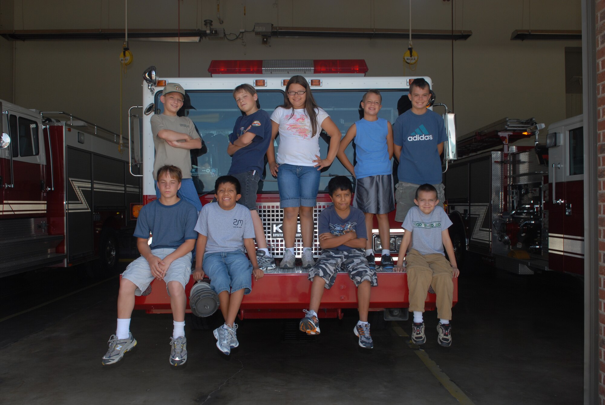 Junior firefighter camp attendees pose for a group photo on one of the fire trucks at the Goodfellow Fire Department. (U.S. Air Force photo by Airman 1st Class Kamaile Chan)