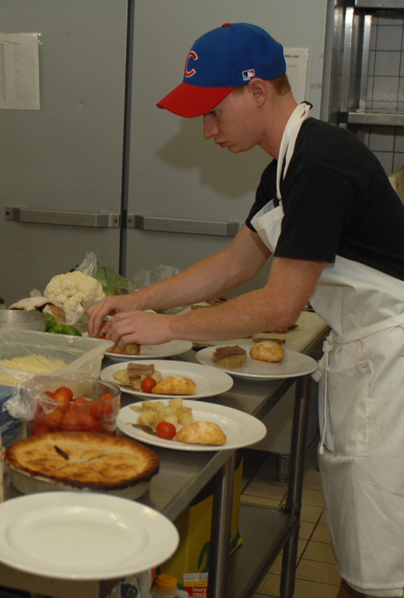 SPANGDAHELM AIR BASE, Germany – Airman Matthew Donlin, 52nd Component Maintenance Squadron, prepares plates for presentation to the judges during the Spangdahlem Air Base Iron Chef competition July 25. The participants were given a time limit of two hours to create a minimum of two entrees from a bag of unknown ingredients. All ingredients had to be used in some way. (U.S. Air Force photo/Airman 1st Class Stephanie Clark)