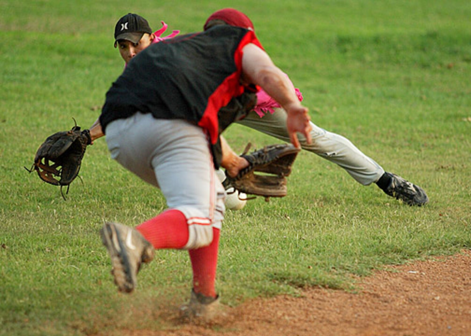 AMMO's Esteban Quintana dives for a grounder as it passes under the glove of Corey Genzel during the first game of the championship.  AMMO went on to win the second game 11-10 over the 728th Air Mobility Squadron. (U. S. Air Force photo by Ismael Gomez)