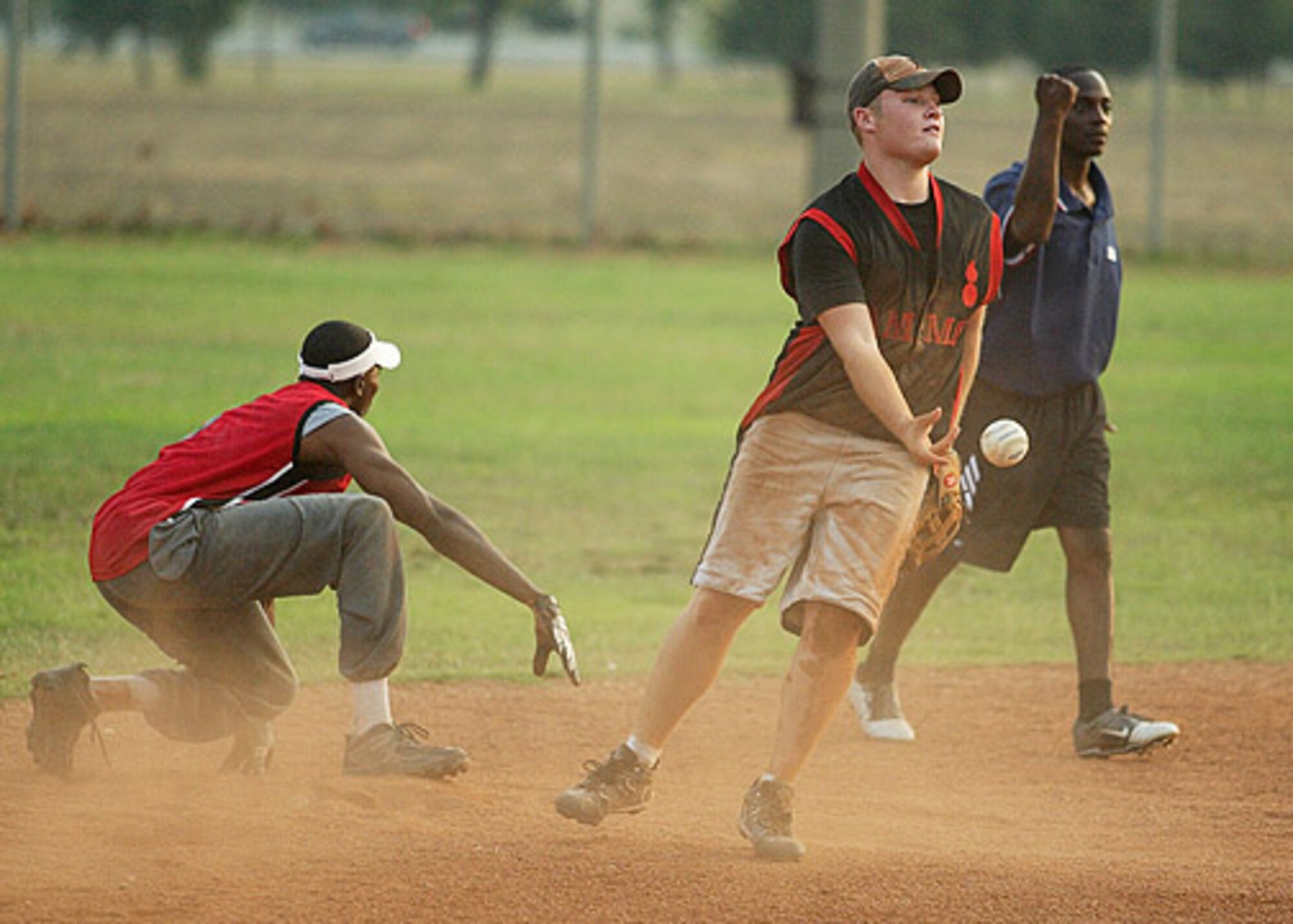 AMS' Tavis Hundley looks at the umpire Brian Shipman for the call as Blake Woodham tosses the ball to the pitcher.  AMMO went on to win the second game 11-10 over the 728th Air Mobility Squadron. (U. S. Air Force photo by Ismael Gomez)
