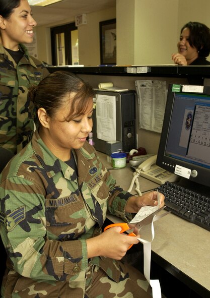 Senior Airman Corina Manzanares, 36th Security Forces Squadron, trims the edges off of a visitors pass at the visitor center, July 26, 2006. (U.S. Air Force photo by Senior Airman Miranda Moorer)                              