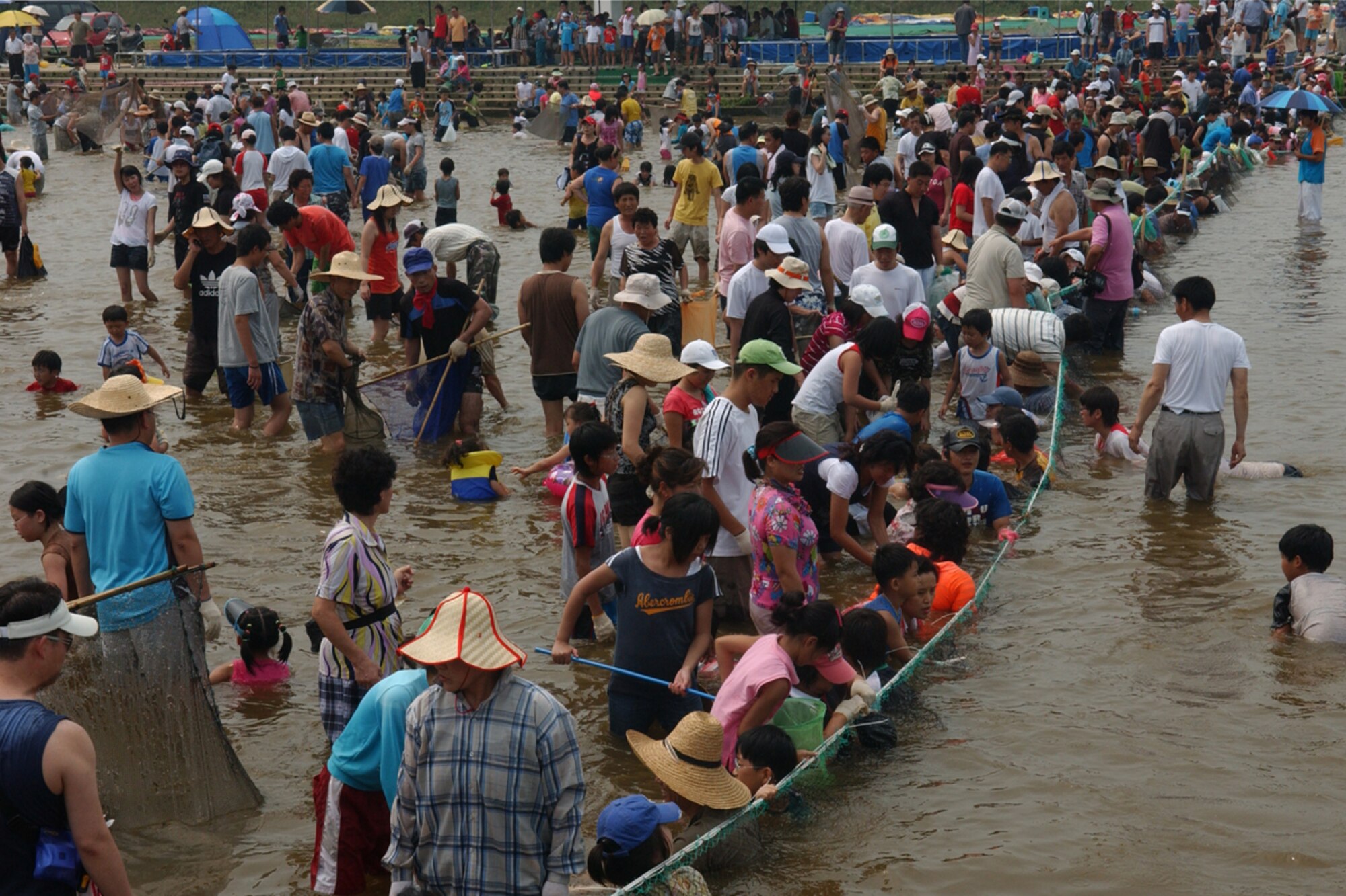 OSAN AIR BASE, Republic of Korea --  Citizens of Pyongtaek and visitors take part in the 4th Annual “Catch Fishes by Hands” Festival.  The festival was held at the Jinwi River, near the city of Pyongtaek and Osan AB, on Aug. 3. During the Catch Fishes by Hands Festival Pyongtaek citizens and family members share traditional games, pottery making, fish sales, tug-of-war in the water, singing competitions and more.  The community also welcomed members from Team Osan to come and partake in the festival.   (U.S. Air Force photo by Staff Sgt. Christopher A. Marasky)