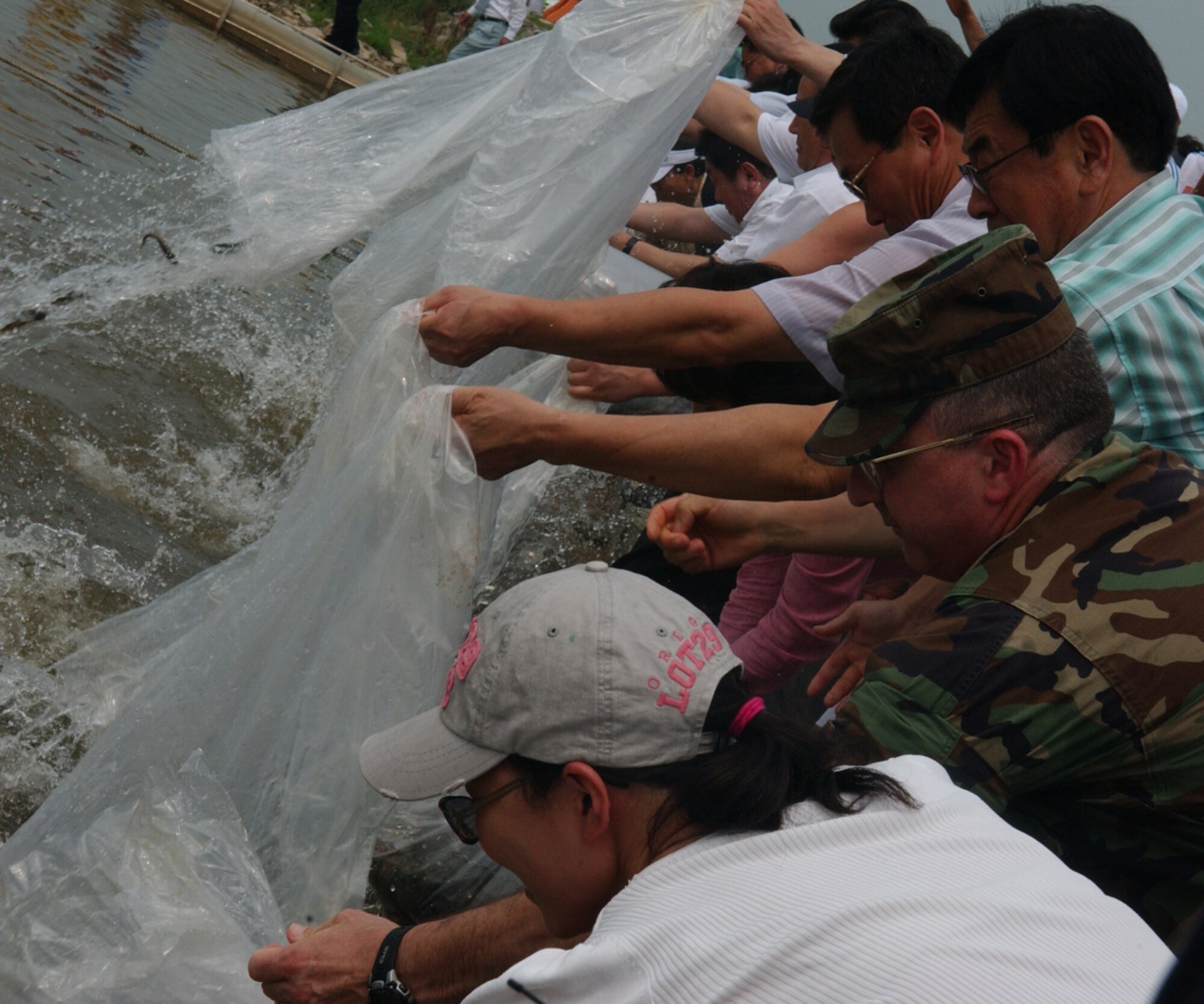OSAN AIR BASE, Republic of Korea --  Cols. Michael A. Canna, 607th Air Intelligence Group commander, and Marilyn H. Howe, 51st Mission Support Group commander, assist in the opening ceremonies of the 4th Annual “Catch Fishes by Hands” Festival.  The festival was held at the Jinwi River, near the city of Pyongtaek and Osan AB, on Aug. 3. During the Catch Fishes by Hands Festival, Pyongtaek citizens and family members share traditional games, pottery making, fish sales, tug-of-war in the water, singing competitions and more. The community also welcomed members from Team Osan to come and partake in the festival.  (U.S. Air Force photo by Staff Sgt. Christopher A. Marasky)