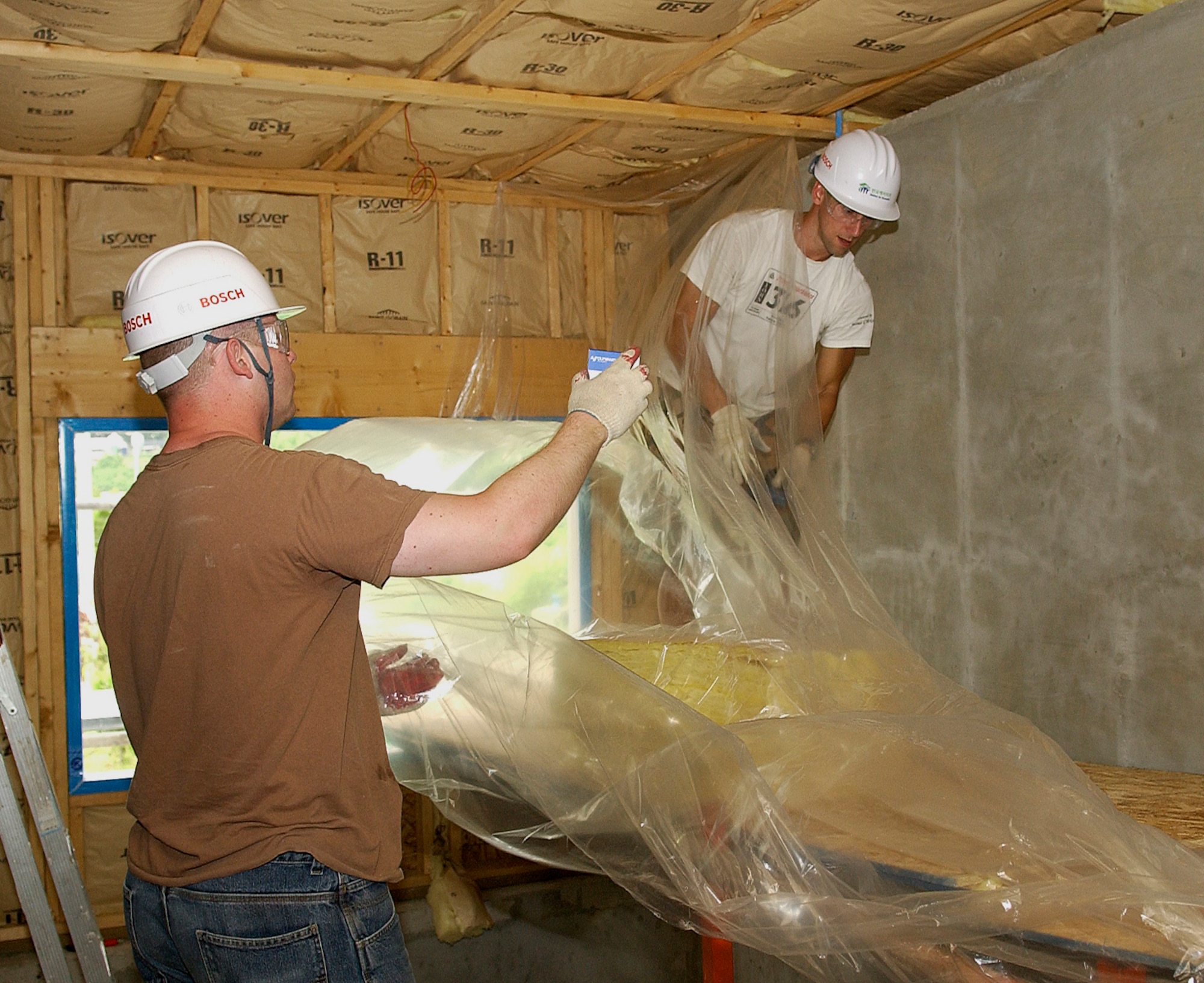 GUNSAN CITY, Republic of Korea -- Captain Timothy Stout, 8th Fighter Wing and Senior Airman Anthony Philllips, 8th Communications Squadron work on interior of a Habitat for Humanity house Aug. 1 here. Airmen from Kunsan Air Base and Korean university students worked together to all week building Habitat for Humanity homes for Gunsan City families. (U.S. Air Force photo/Senior Airman Giang Nguyen)  
                               
                               
                               