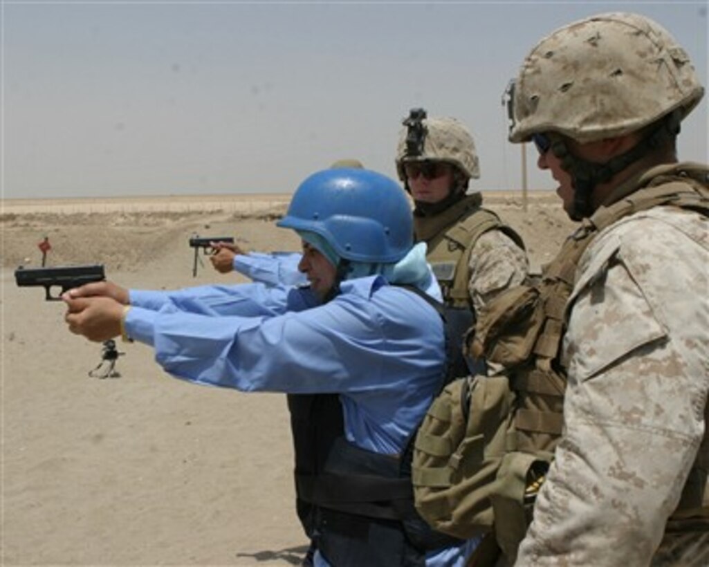 Iraqi female police officers fire pistols under the watchful eye of U.S. Marines at the pistol range on Joint Security Station Iron in Ramadi, Iraq, on July 28, 2007.  The female officers are being trained by fellow police officers and U.S. Marines from the 2nd Battalion, 5th Marine Regiment, 3rd Infantry Division, II Marine Expeditionary Force.  