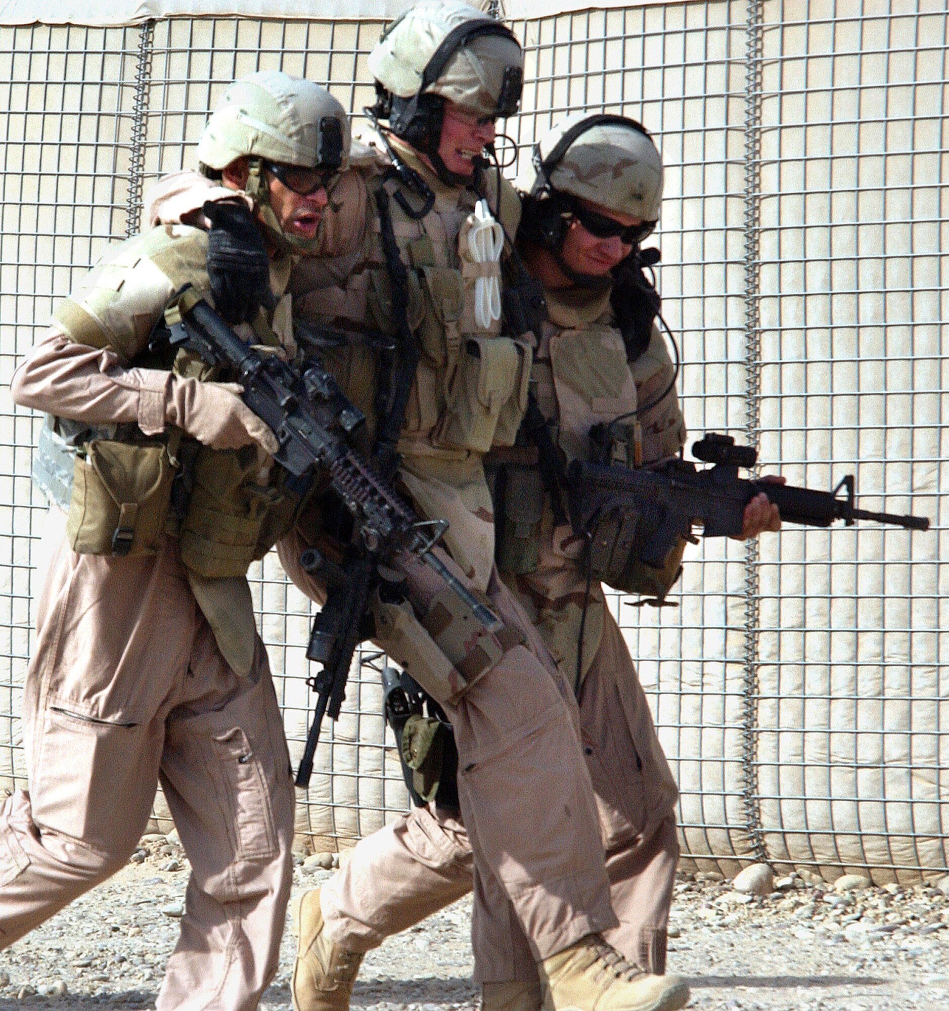 Master Sgt. Killjan Anderson (left) and Senior Airman John Bretzik, help an "injured" Staff Sgt. Dwayne Pyle back to waiting Humvees during "battle drills" performed before each mission at Contingency Operating Base Speicher, Iraq. All three are members of the 732nd Expeditionary Security Forces Squadron Det. 6 and perform duties as a Provincial Police Transition Team. The drills are designed to simulate any possible situation the team may encounter while conducting missions outside the wire. The PTTs goal is to help the Iraqis establish a functioning, independent police force. (U.S. Air Force photo/Master Sgt. Steve Horton)