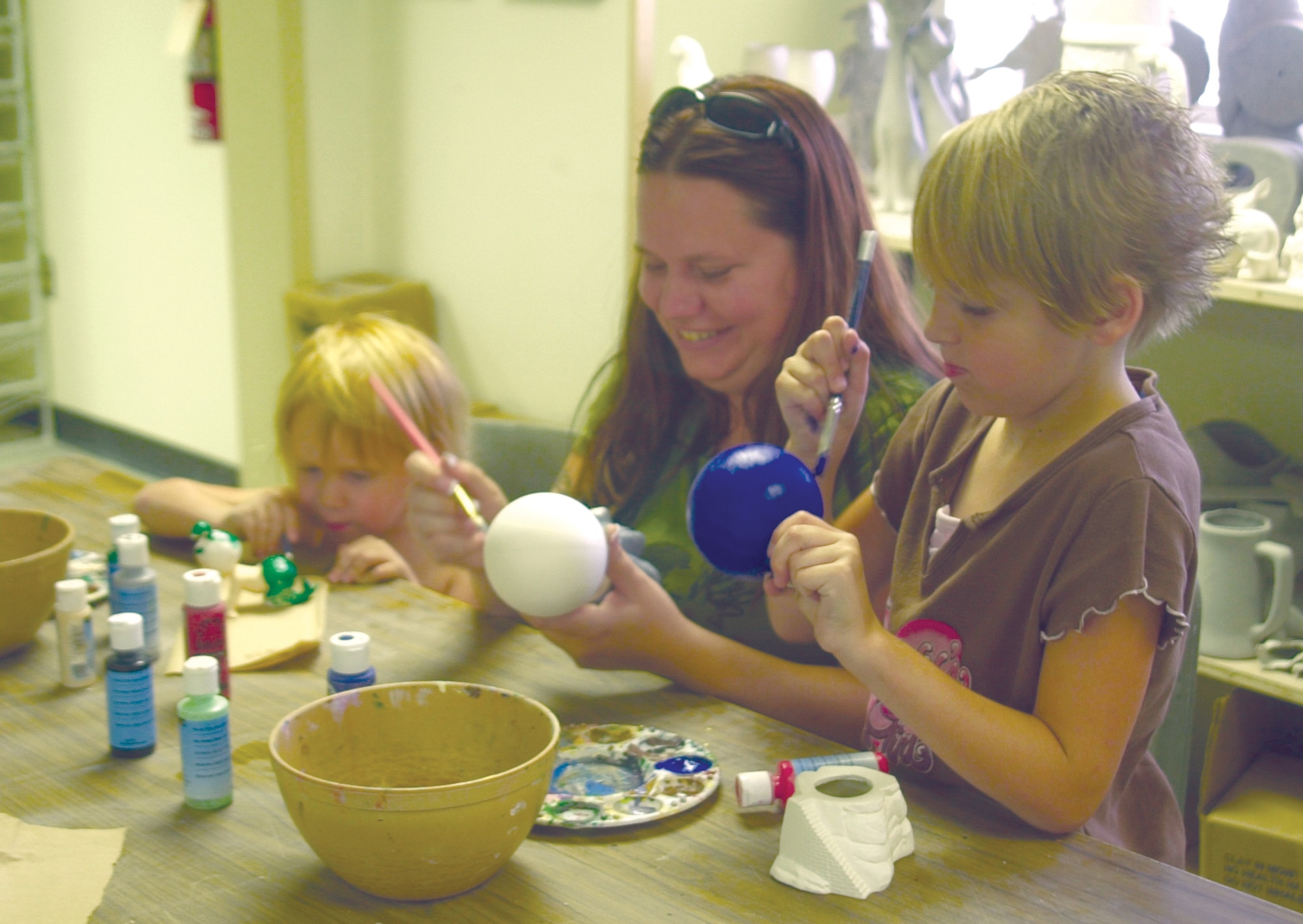 From left to right: Adrienne, Amber and Jasmine Arnold paint a coat of glaze on mold-cast ceramics July 10 at the Arts and Crafts Center. (U.S. Air Force photo by Airman 1st Class Stephen Musal)