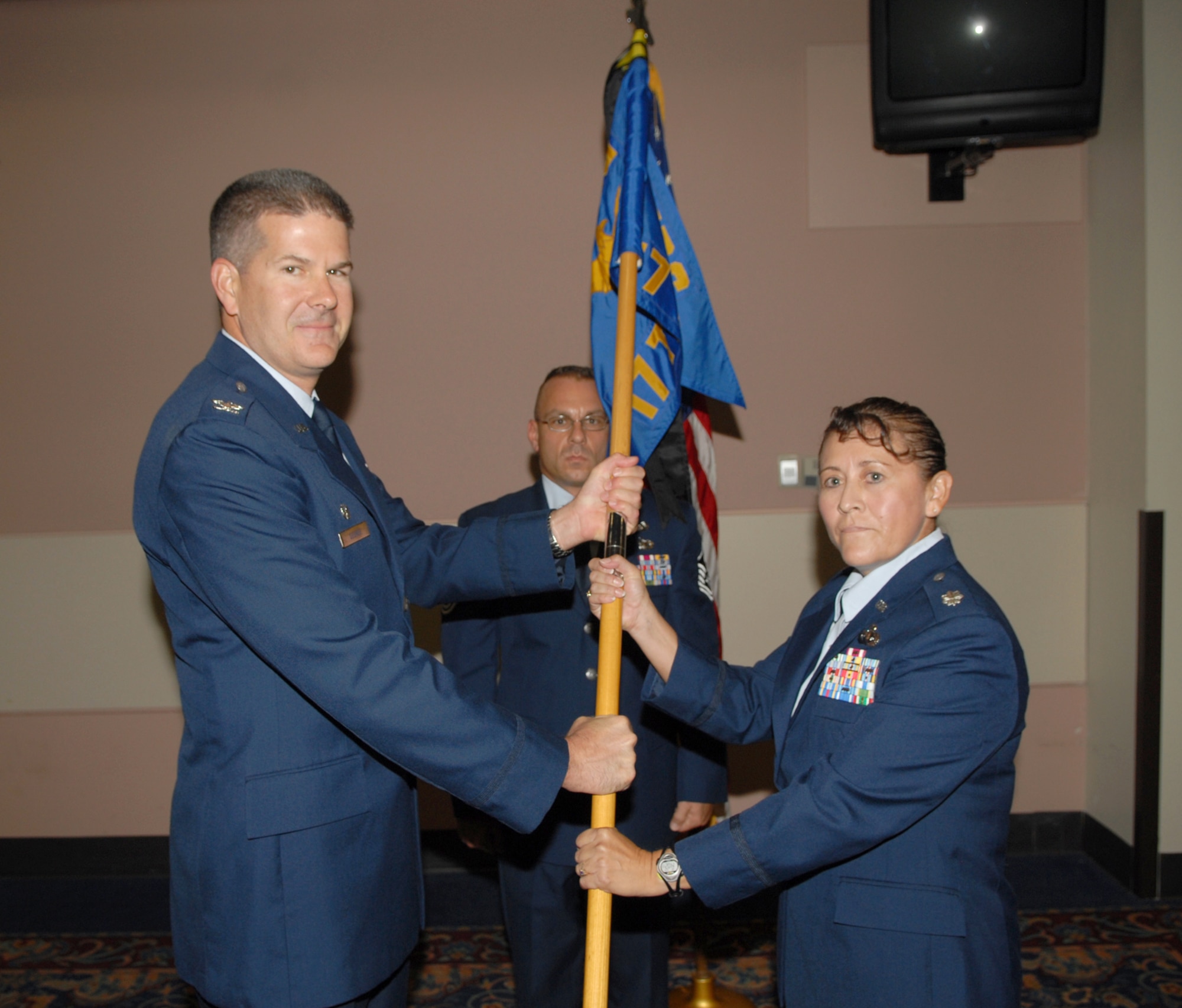 (Left) Col. D. Scott George, 17th Training Group commander, passes the 17th Training Support Squadron guidon to Lt. Col. Georgette Young Wednesday at the Goodfellow Event Center. Lieutenant Col. Young replaced Lt. Col. Robert Ehlers. (U.S. Air Force photo by Staff Sgt. John Barton)