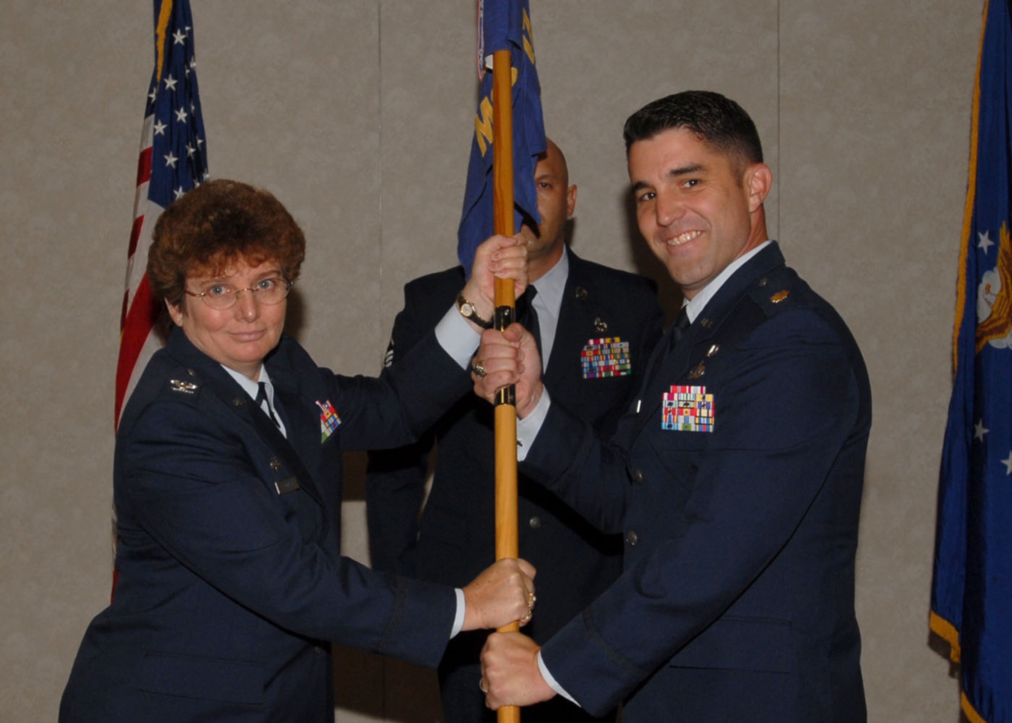 (Left) Col. Ada Conlan, 17th Mission Support Group commander, passes the 17th Contracting Squadron guidon to Maj. Michael Hulin Wednesday at the Goodfellow Event Center. Major Hulin replaced Maj. Louis Orndorff. (U.S. Air Force photo by Tech. Sgt. Gina O’Bryan)