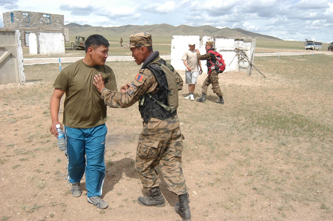 FIVE HILLS TRAINING CENTER, Mongolia (Aug. 5, 2007) â?? Mongolian Armed Forces soldiers fend off civilians during cordon and search training here Aug. 5. This training is just one of six lanes, or stations, approximately 1,000 multinational service members will go through during exercise Khaan Quest 07. (Official U. S. Marine Corps photo by Sgt. G. S. Thomas)