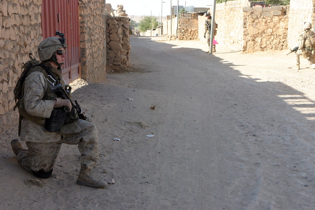 KARABALAH, Iraq ? Marines with Alpha Company, Task Force 1st Battalion, 4th Marines, attached to Regimental Combat Team 2, cordon off a house, securing the Marines and homeowners inside from any possible attacks during a patrol stop.  Marines normally stop on patrols to speak with homeowners about insurgent activity and to find out if they need any help the Marines could provide.