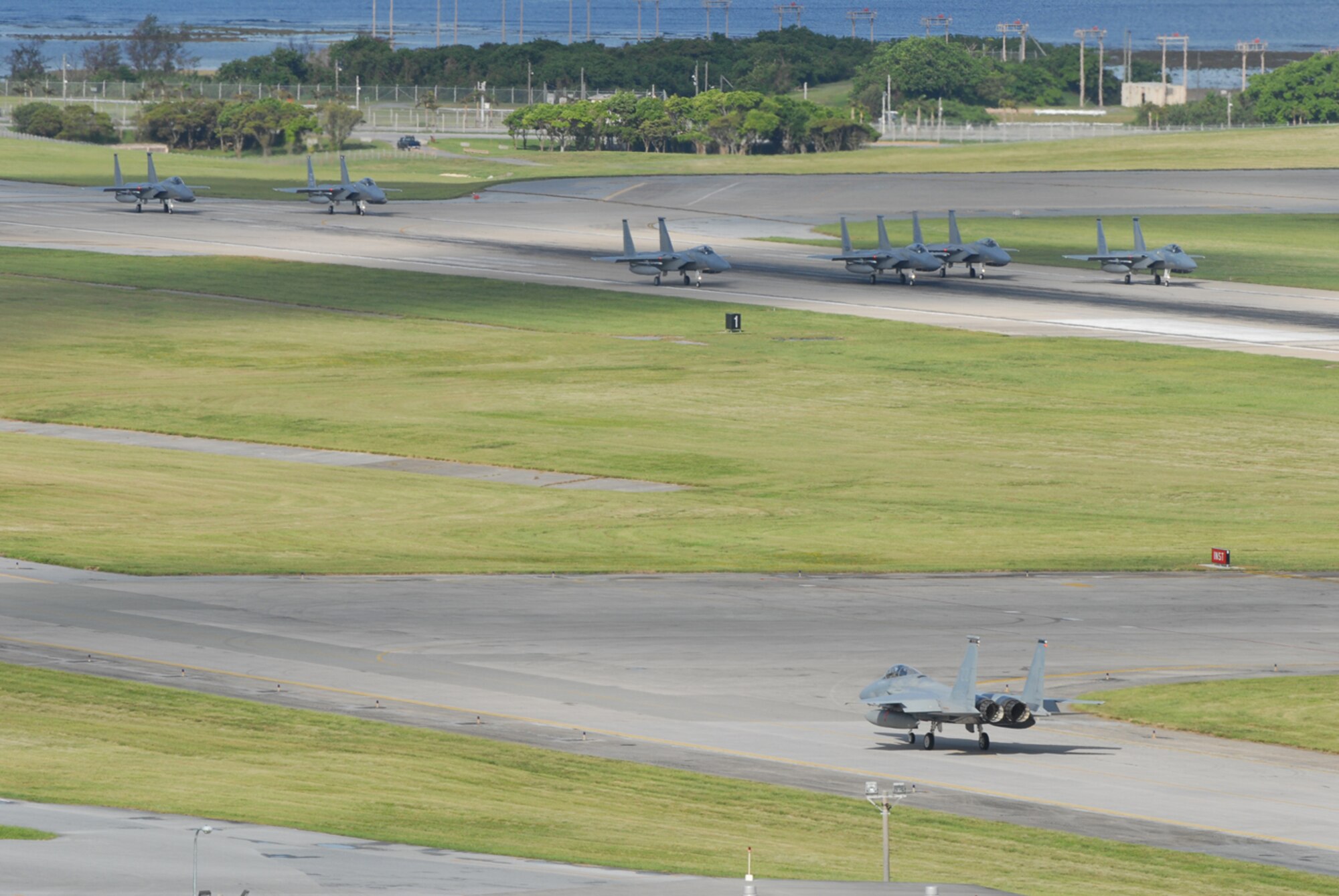 Six 18th Wing F-15C Eagles prepare to take off while a seventh taxis into position at Kadena Air Base, Japan, Aug. 5, 2007, en route to Guam in support of Exercise Valiant Shield.  More than 400 Airmen and F-15Cs, KC-135R Stratotankers and E-3 Airborne Warning and Control System aircraft are participating in the weeklong Pacific Command joint exercise which focuses on integrated joint training to enable real-world proficiency in sustaining forces and detecting, locating, tracking and engaging units at sea, in the air, on land, and cyberspace in response to a range of mission areas. U.S. Air Force photo/Senior Airman Darnell T. Cannady