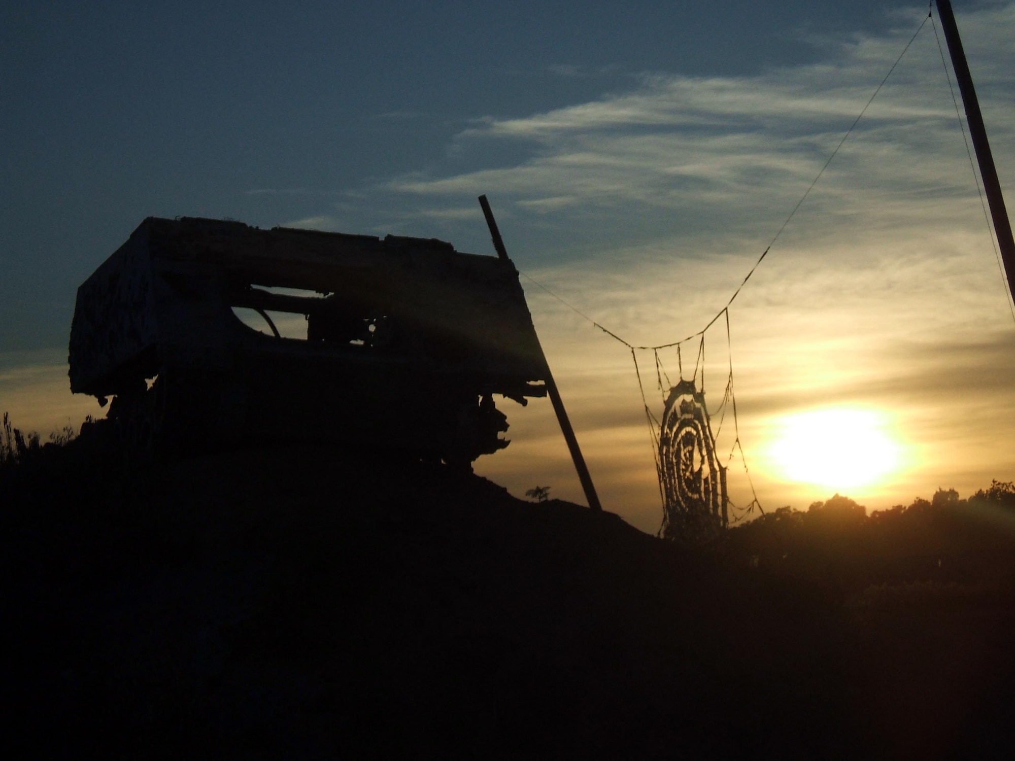 The setting sun sillhouettes the strafing pit at Cannon Range, near Ft. Leonard Wood, Mo.  On the left is an old armored personnel carrier used as a target by pilots making strafing runs at the range, as well as a target net hung between two poles.  The range is vital to the continuous training of A-10 pilots from the Air Force Reserve's 442nd Fighter Wing at Whiteman Air Force Base, Mo., as well as pilots from other Reserve, Guard and active-duty units across the country.  Cannon Range is managed and operated by the Missouri Air National Guard's 131st Fighter Wing.  (U.S. Air Force photo/Tech. Sgt. Leo Brown)