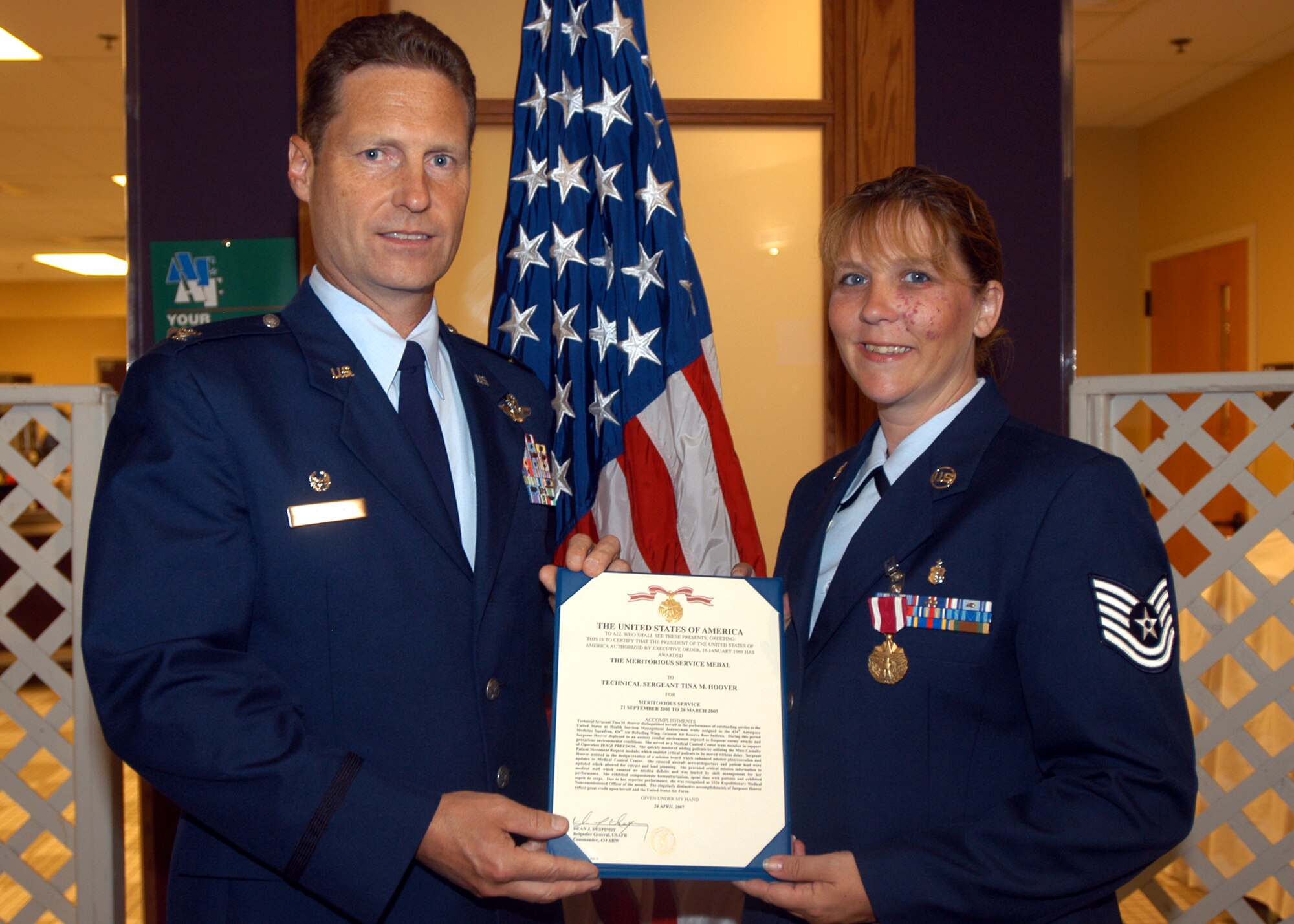GRISSOM AIR RESERVE BASE, Ind., -- Tech. Sgt. Tina Hoover, 434th Mission Support Squadron, right, receives an Air Force Meritorious Service Medal from Col. Doug McHugh, 434th Mission Support Group commander, during a commander's call held on the August unit training assembly. Sergeant Hoover was recognized for her years of service and excellence while she was a member of the 434th Aerospace Medicine Squadron. (U.S. Air Force photo/Tech. Sgt. Doug Hays)