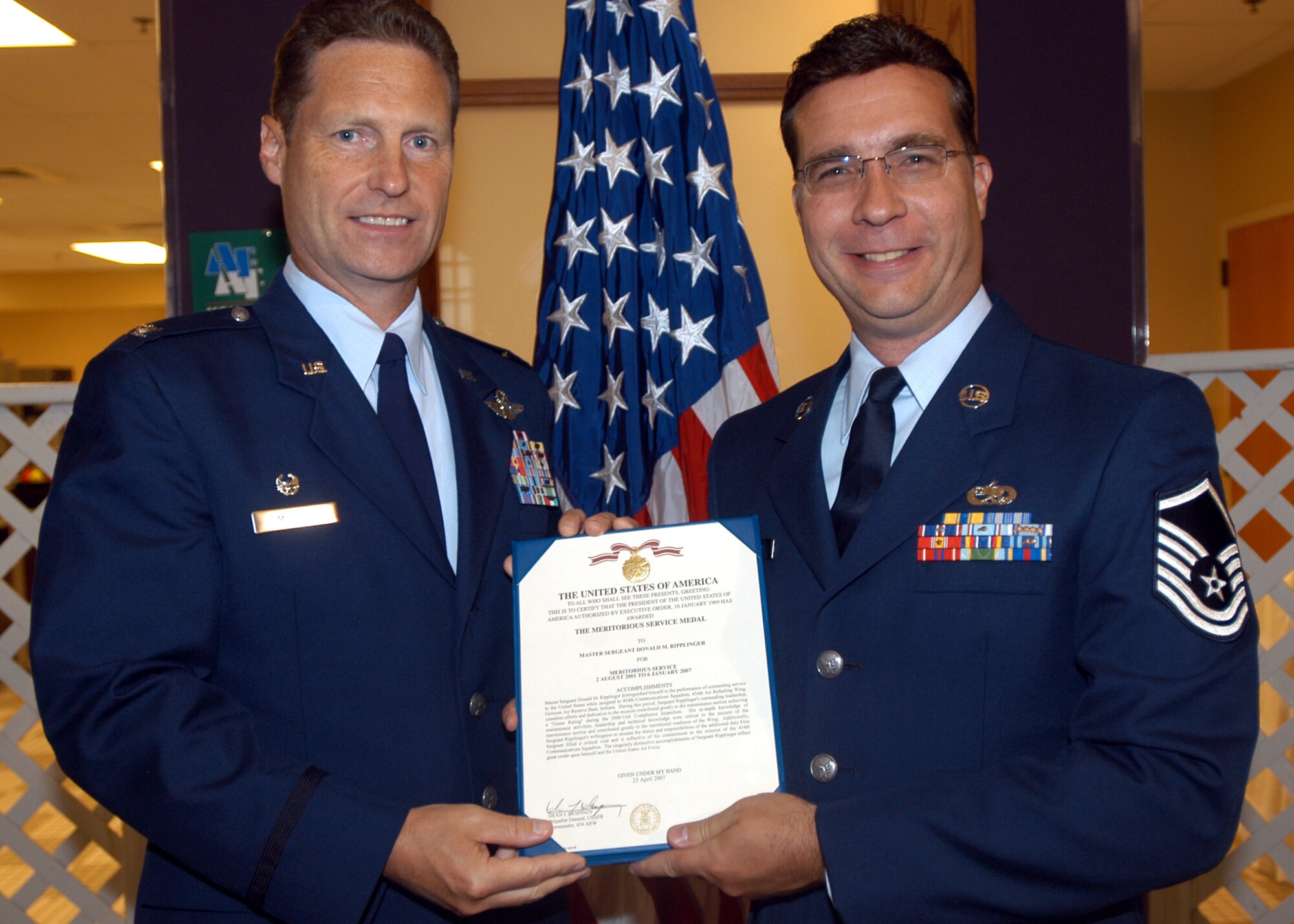 GRISSOM AIR RESERVE BASE, Ind., -- Master Sgt. Don Ripplinger, 434th Communicatiionsn Squadron, right, receives an Air Force Meritorious Service Medal from Col. Doug McHugh, 434th Mission Support Group commander, during a commander's call held on the August unit training assembly. Sergeant Ripplinger was recognized for his excellent service and leadership with in the communications squadron. (U.S. Air Force photo/Tech. Sgt. Doug Hays)