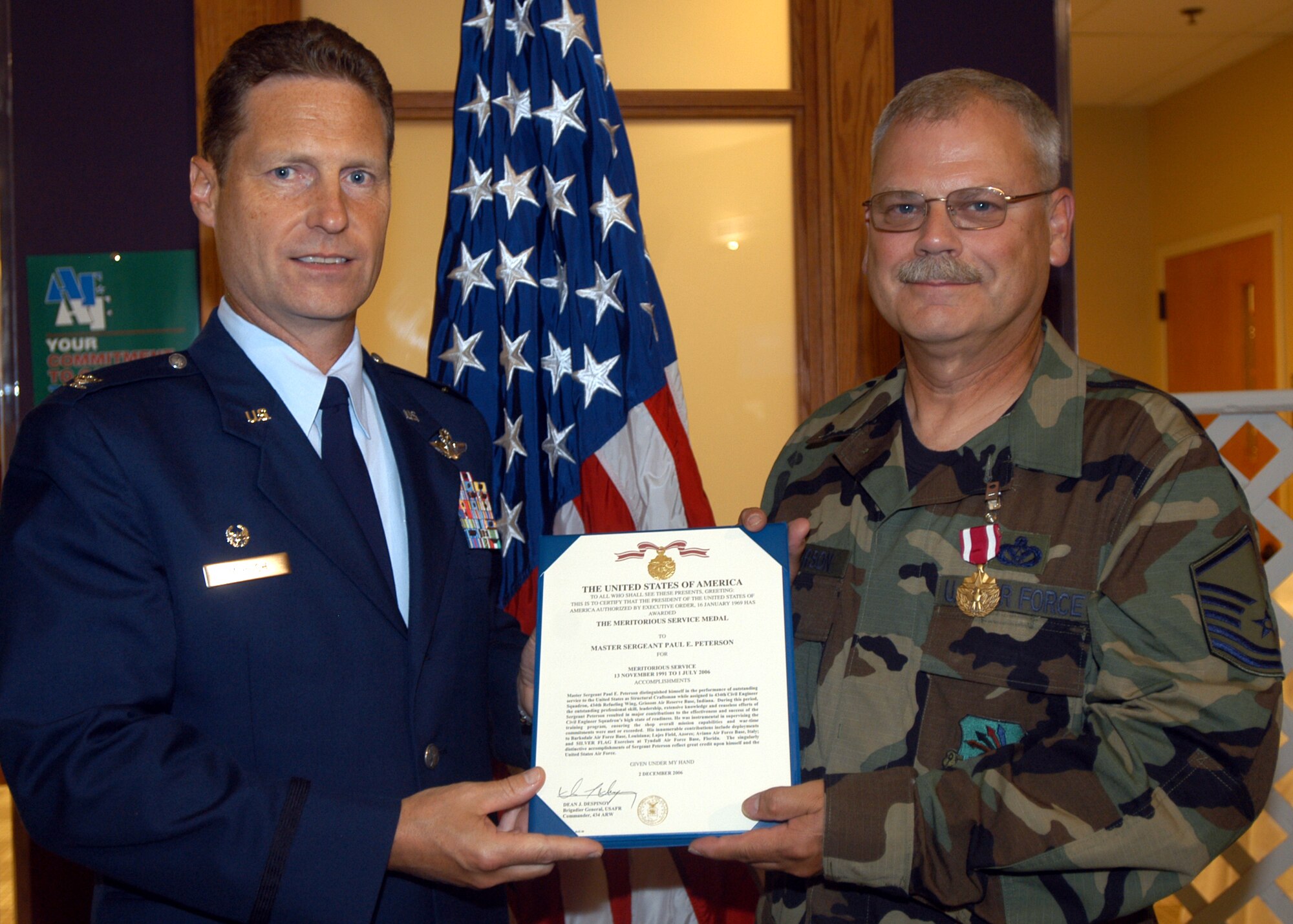 GRISSOM AIR RESERVE BASE, Ind., -- Master Sgt. Paul Peterson, 434th Civil Engineering Squadron, right, receives an Air Force Meritorious Service Medal from Col. Doug McHugh, 434th Mission Support Group commander, during a commander's call. Sergeant Peterson was recognized for his excellent service and leadership with the civil engineering unit. (U.S. Air Force photo/Tech. Sgt. Doug Hays)