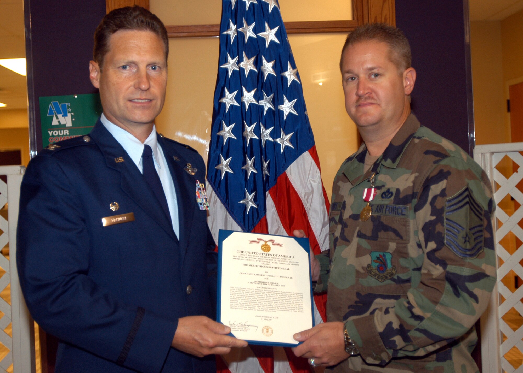 GRISSOM AIR RESERVE BASE, Ind., -- Chief Master Sgt. Michael Bowden, 434th Civil Engineering Squadron, right, receives an Air Force Meritorious Service Medal from Col. Doug McHugh, 434th Mission Support Group commander, during a commander's call. Chief Bowden was recognized for his excellent service and leadership with in the civil engineering unit. (U.S. Air Force photo/Tech. Sgt. Doug Hays)
