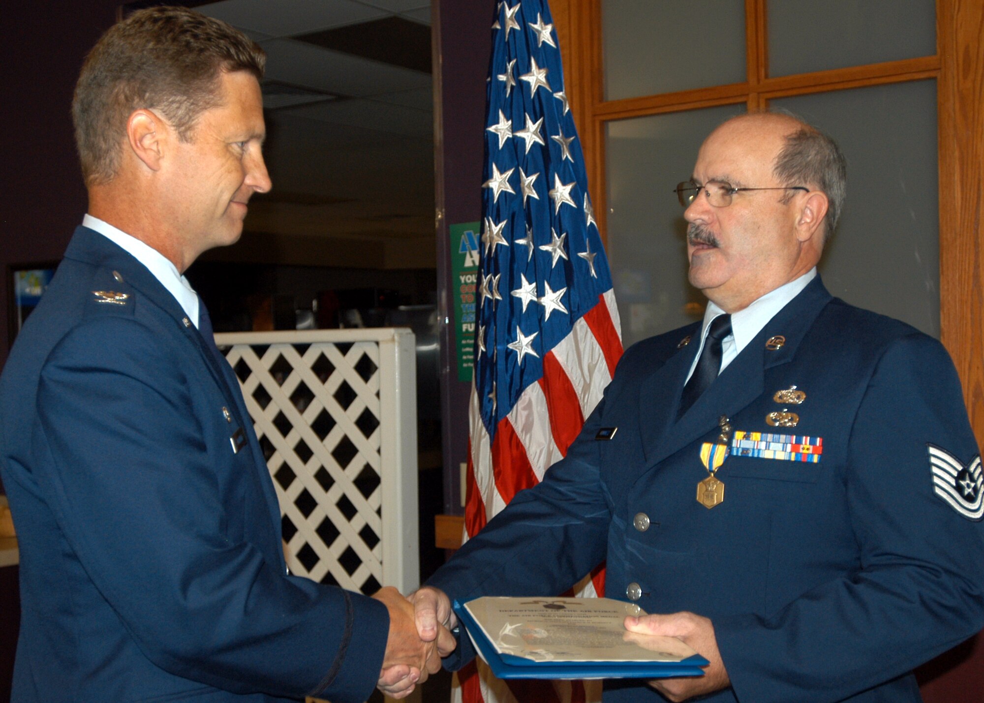 GRISSOM AIR RESERVE BASE, Ind., -- Tech. Sgt. Patrick Kuminecz, 434th Communications Squadron, right, receives an Air Force Commendation Medal from Col. Doug McHugh, 434th Mission Support Group commander, during a commander's call held on the August unit training assembly. Sergeant Kuminecz was recognized for his excellent service and leadership within the communications career field. (U.S. Air Force photo/Tech. Sgt. Doug Hays)