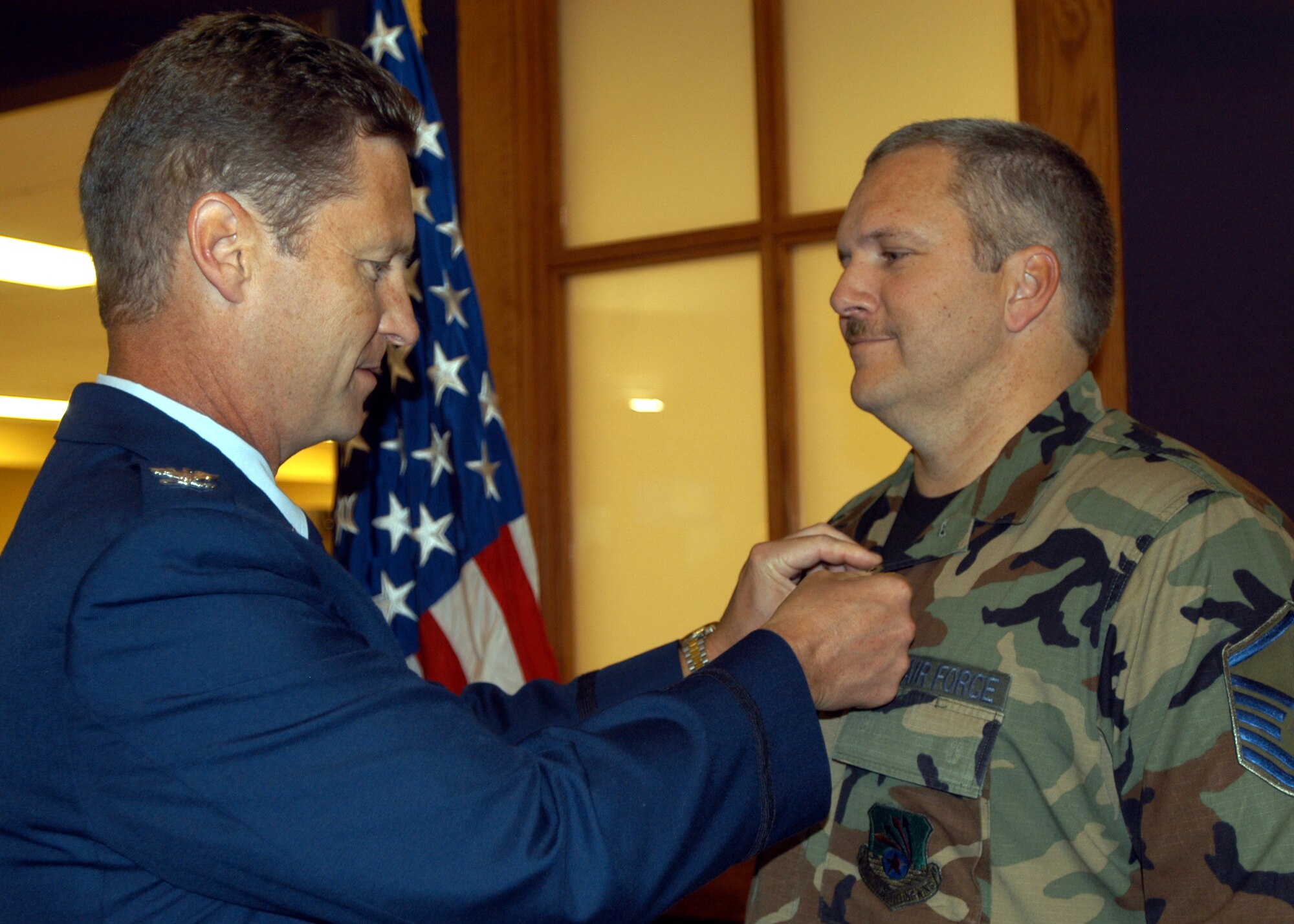 GRISSOM AIR RESERVE BASE, Ind., -- Master Sgt. Robert Sanders, 434th Civil Engineering Squadron, right, receives an Air Force Meritorious Service Medal from Col. Doug McHugh, 434th Mission Support Group commander, during a commander's call held on the August unit training assembly. Sergeant Sanders was recognized for his devotion to duty and excellent service within the civil engineering unit. (U.S. Air Force photo/Tech. Sgt. Doug Hays)