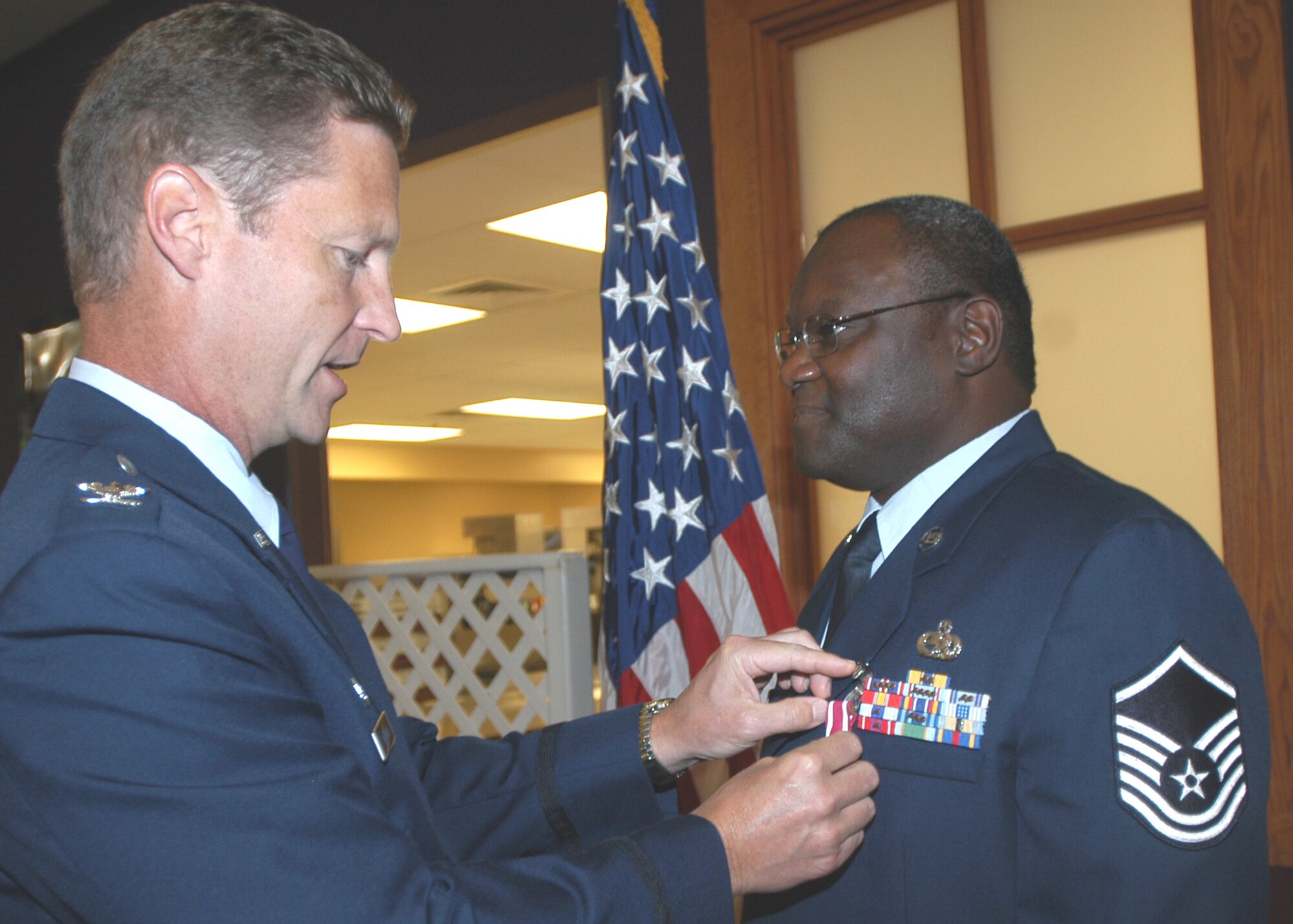 GRISSOM AIR RESERVE BASE, Ind., -- Master Sgt. Ethan Minor, 434th Communications Squadron, right, receives an Air Force Meritorious Service Medal from Col. Doug McHugh, 434th Mission Support Group commander, during a commander's call held on the August unit training assembly. Sergeant Minor was recognized for his excellence and dedication to duty. (U.S. Air Force photo/Tech. Sgt. Doug Hays)