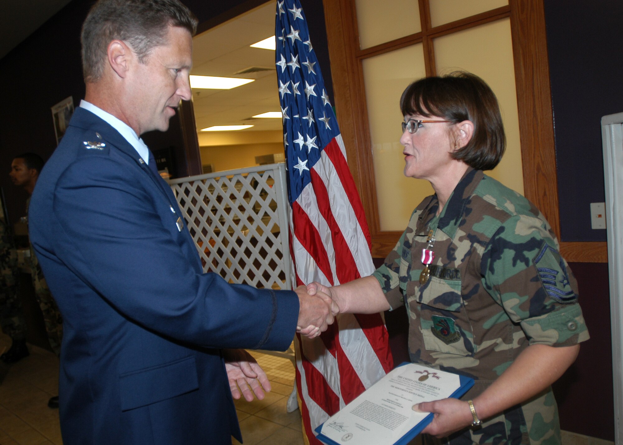 GRISSOM AIR RESERVE BASE, Ind., -- Master Sgt. Melissa Binns, Airman and Family Readiness Office, right, receives an Air Force Meritorious Service Medal from Col. Doug McHugh, 434th Mission Support Group commander during a commander's call held on the August unit training assembly. Sergeant Binns was recognized for her excellence and dedication to service. (U.S. Air Force photo/Tech. Sgt. Doug Hays)