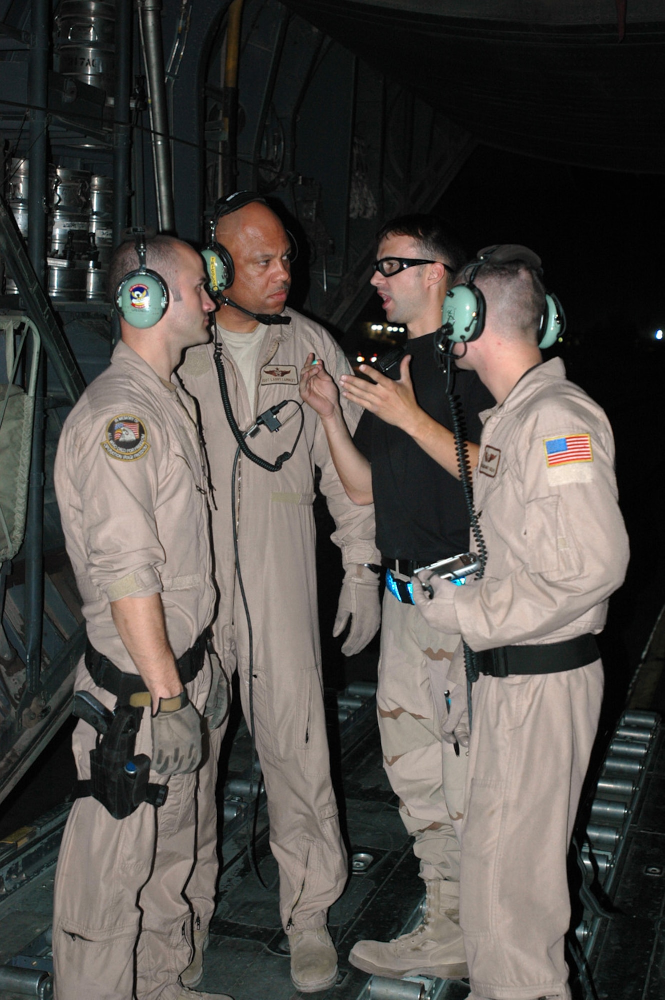 Following the airdrop mission over Basra, Iraq, the C-130 crew headed for Balad Air Base, Iraq, to continue their night’s mission. Master Sgt. Larry Lambert, Staff Sgt. Tommy Greeness and Airman 1st Class Zachary Kelhi, 746th Expeditionary Airlift Squadron loadmasters, are met by an Airman upon their arrival there at about 4 a.m.  He informed the crew of what type of cargo they would be taking to Baghdad International Airport. The size, amount and type of cargo are the driving factors of how the loadmasters configure the cargo area of the C-130. In this case it was three pallets of paper that needed to be transported to BIAP.  (U.S. Air Force photo by Capt. Teresa Sullivan)