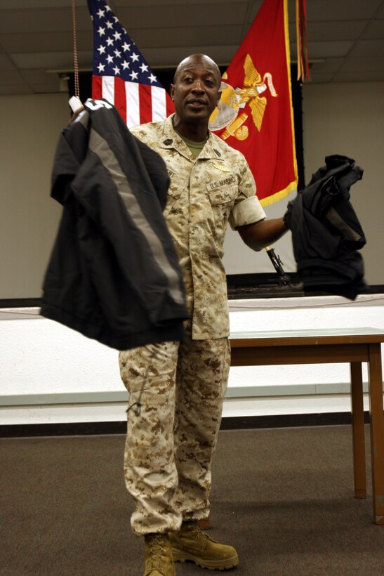 The 16th Sgt. Maj. of the Marine Corps, Sgt. Maj. Carlton Kent shows off a prototype of the new physical fitness uniform to the Marines and Sailors of U.S. Marine Corps Forces, Pacific at the Pollack Theater here Aug. 6.