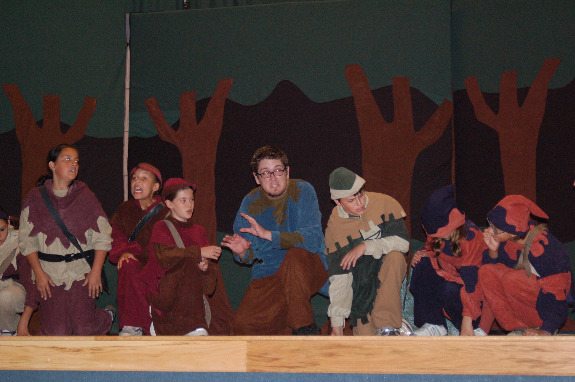 EIELSON AIR FORCE BASE, Alaska--Eielson youth perform the play Robin Hood, presented by the Missoula Childrens Theater July 27 at the base theater.  Here, members of Robin's Merry band try to show him that everyone has a talent. Left to Right:  Elena Rodriguez, Victoria Newbill, Stephanie Brann, Kepler Correia, an MCT staff member who is playing Sherwood, Chris Brewer playing Robin Hood, Emily Stephens and Estella Suarez. (U.S. Air Force photo by Misty Campbell)