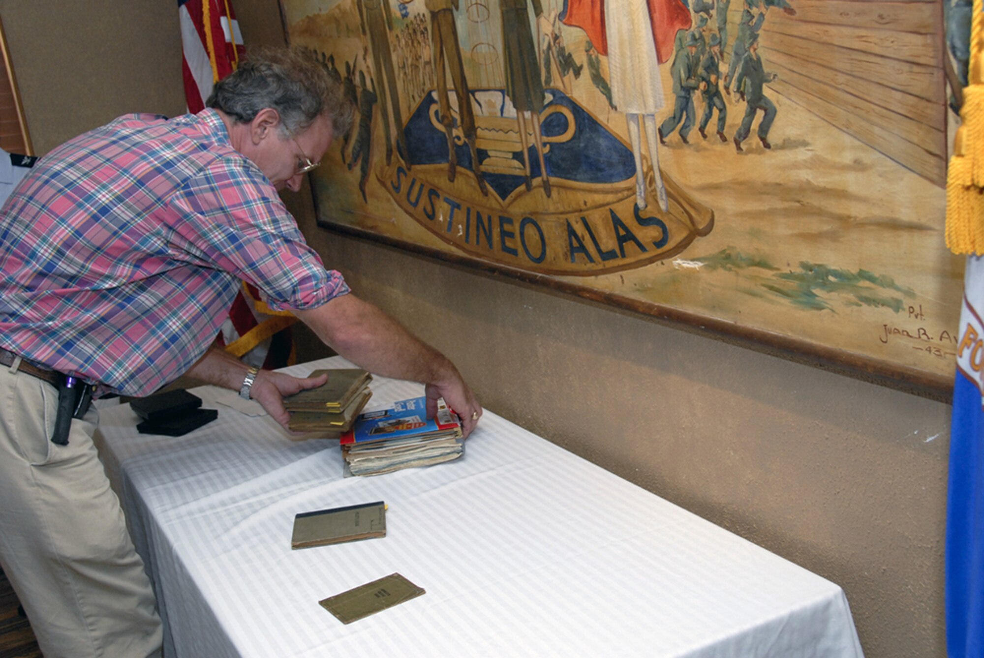 Mr. James Berry, son-in-law of Mrs. Mary Hall, arranges some of the artifacts belonging to Col. William Davidson and his father Brig. Gen. Jospeh Davidson at the base heritage center Aug. 3. (U.S. Air Force photo/Sandy Wassenmiller)