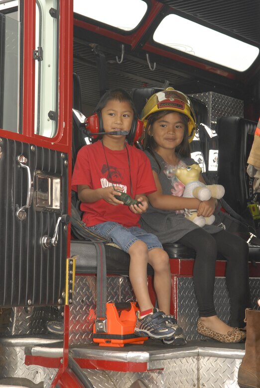 VANDENBERG AIR FORCE BASE, Calif. -- Xanaquin Concepcion, 5 (left), and Haani Meno, 6, pretend to be firefighters on Fire Engine 5 during the 30th Space Wing Touch-a-Truck event held Aug. 4.  The Touch-a-Truck event is sponsored every year by the 30th Services Division to allow parents and their children to get a hands on look at fire engines, armored humvees, loaders, 30-ton aircraft cargo loaders and transporters, and launch vehicle tracking stations work. (U.S. Air Force photo/Airman 1st Class Adam Guy)